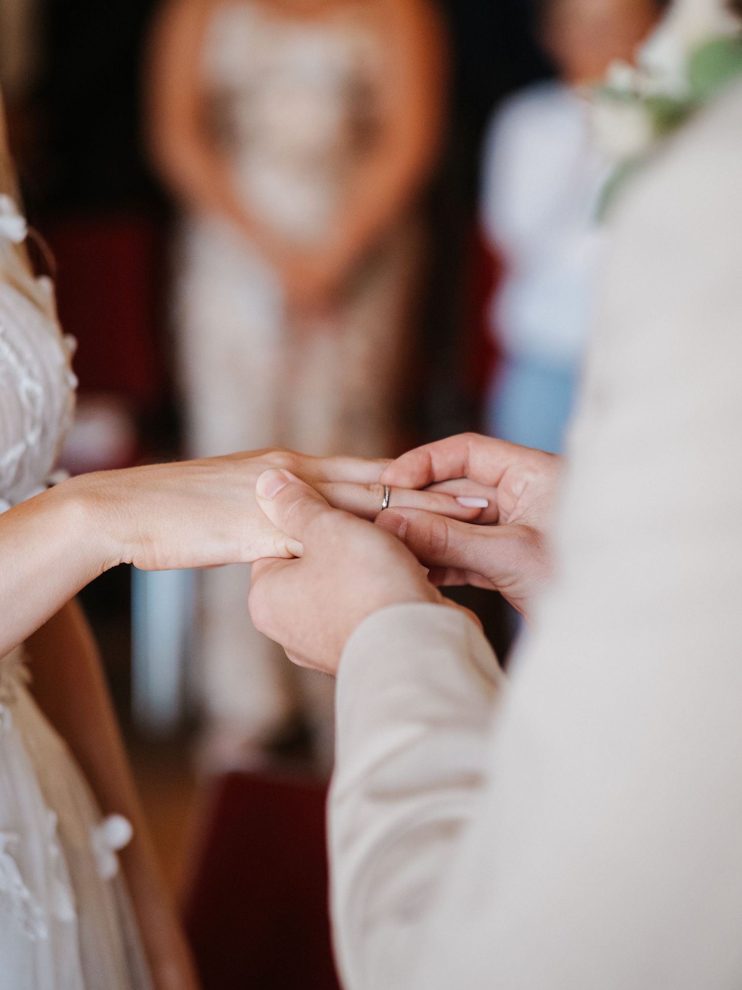 Two hands gently touching during an intimate wedding ceremony moment.