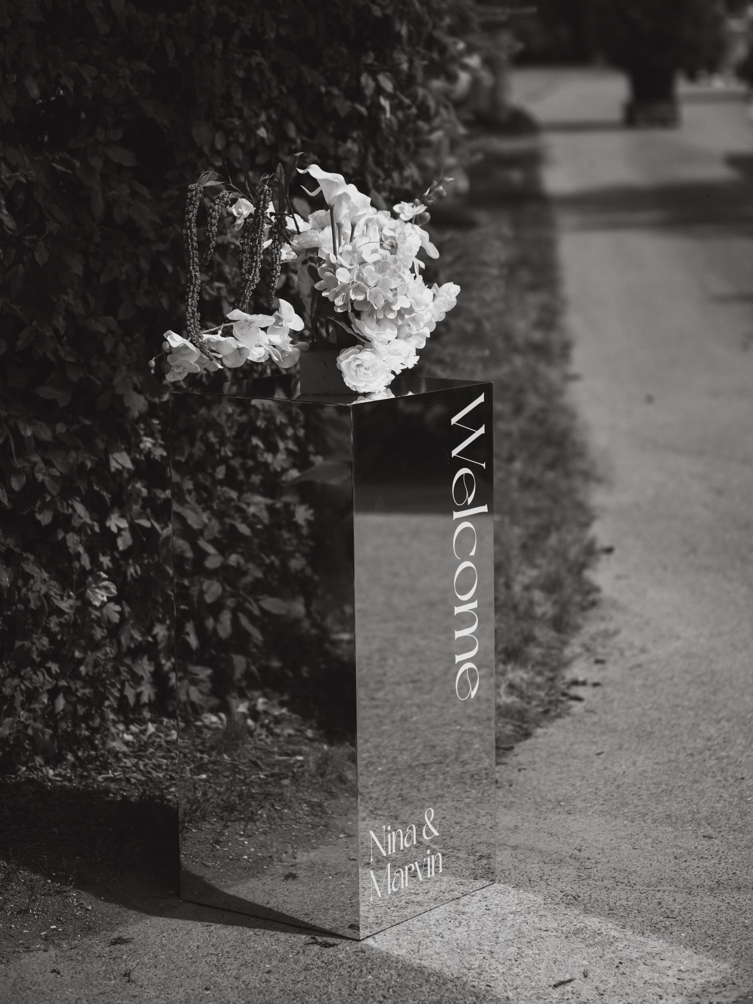 Black and white artistic detail shots of wedding decorations on a textured surface.
