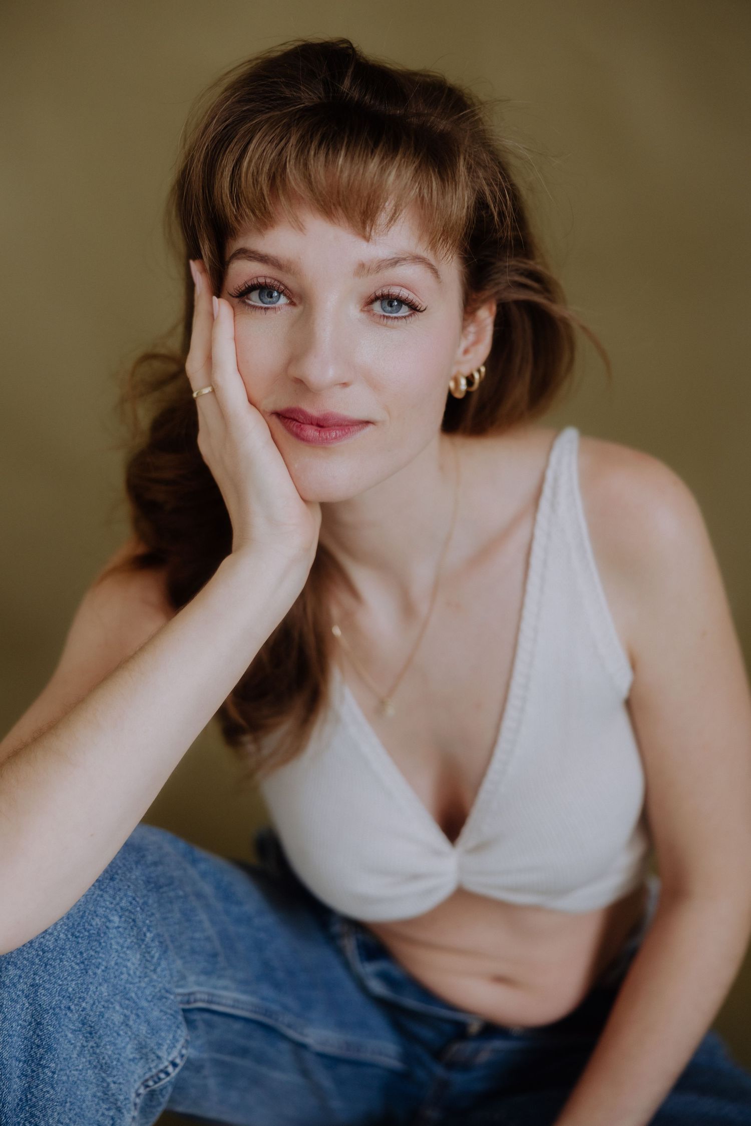 A series of intimate portrait shots showing someone in a white top and denim against a neutral background.