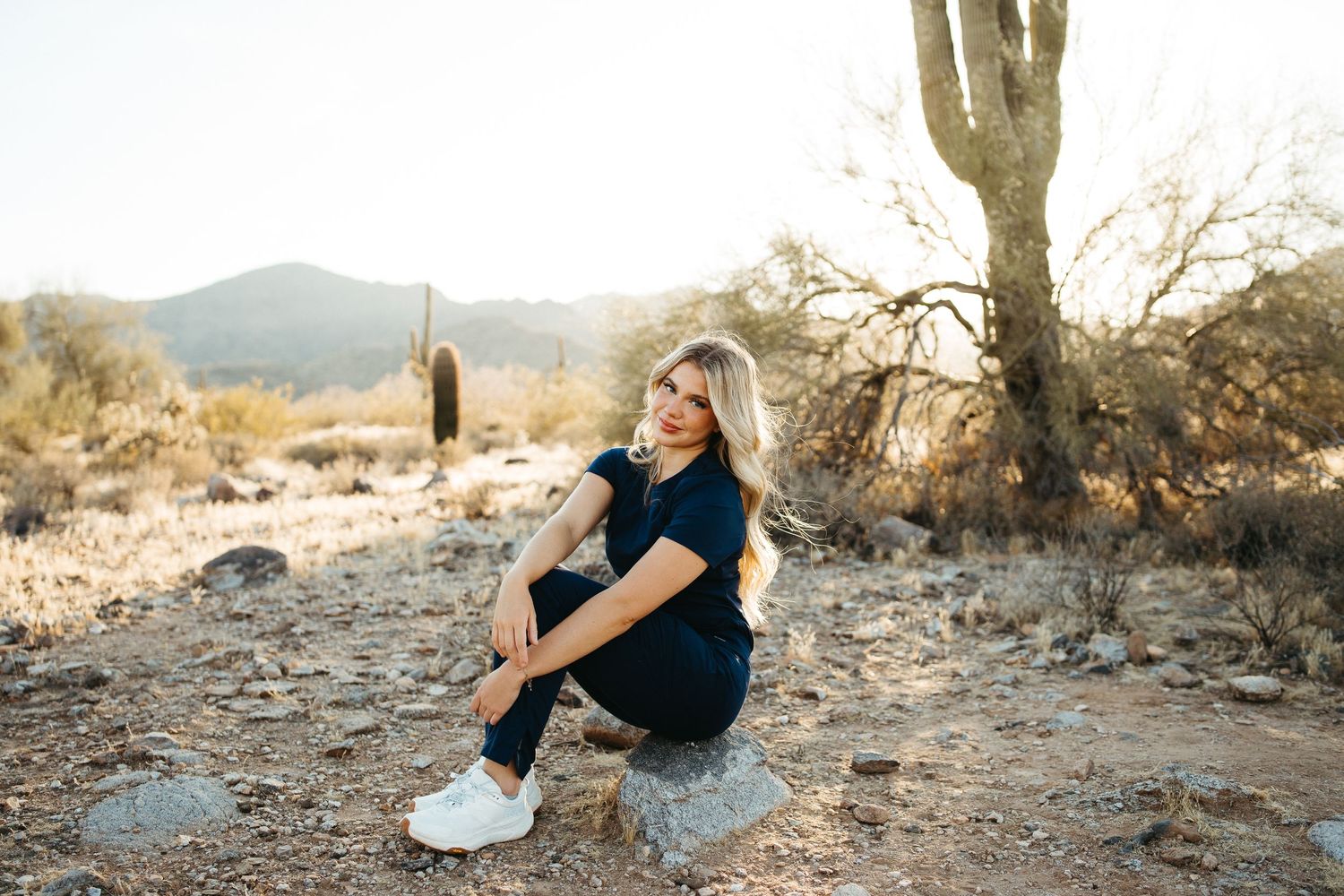 Desert photoshoot with saguaro cactus and mountains during golden hour.