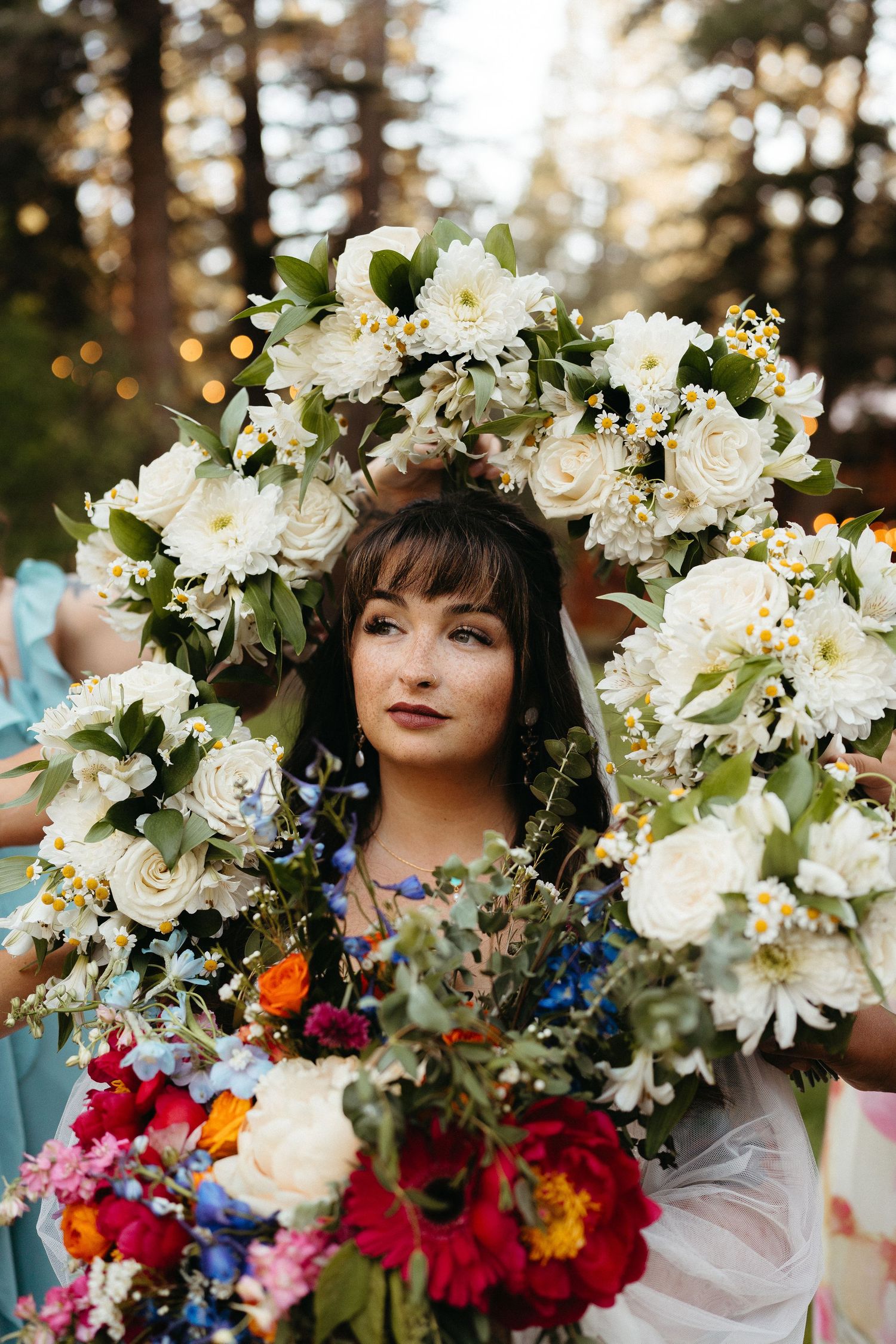 Ethereal floral portrait with white lilies and roses contrasting against vibrant red and pink blooms in natural sunlight.