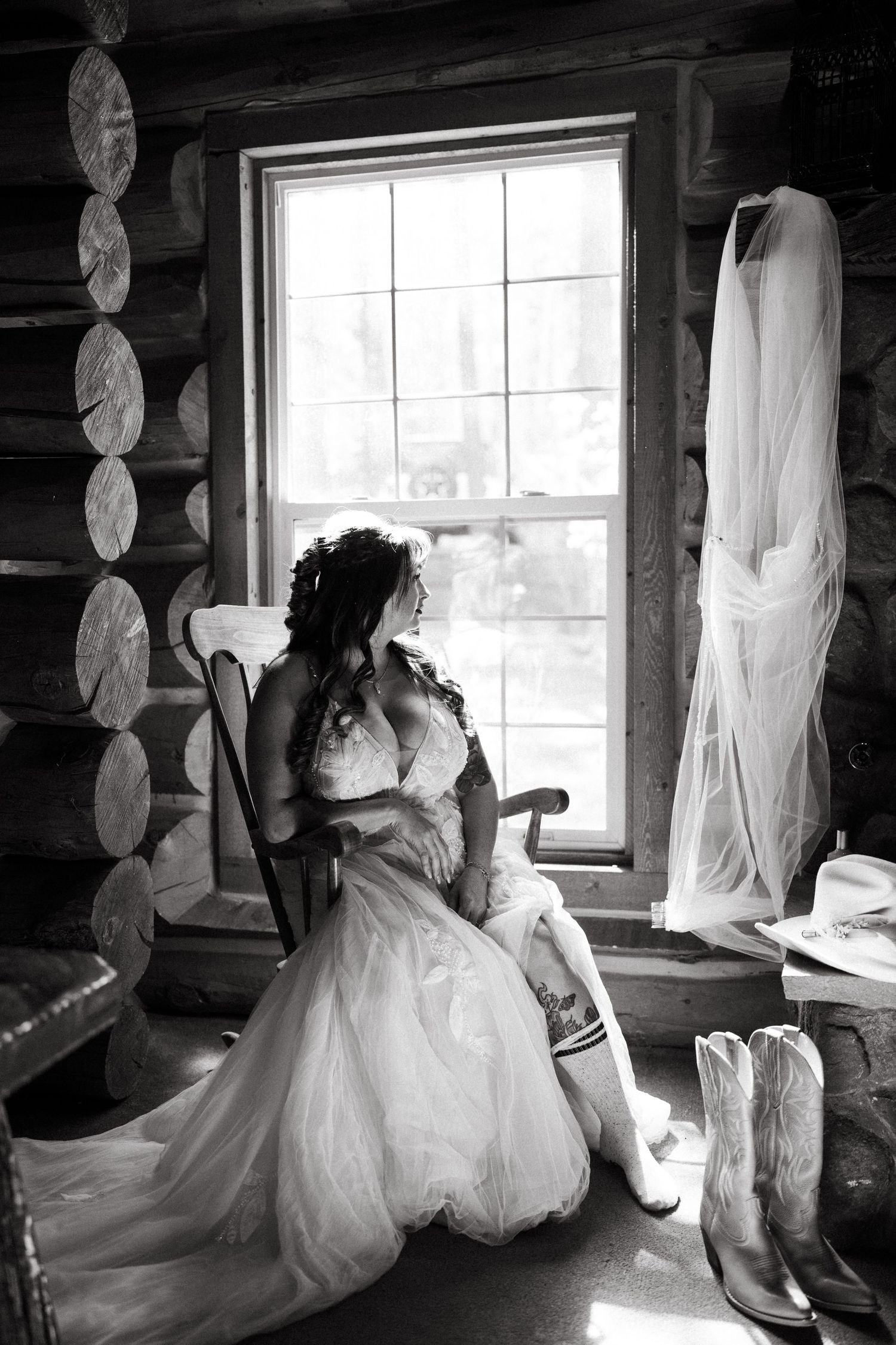 A sequence of black and white photos showing a wedding dress hanging in a rustic cabin window with natural light.