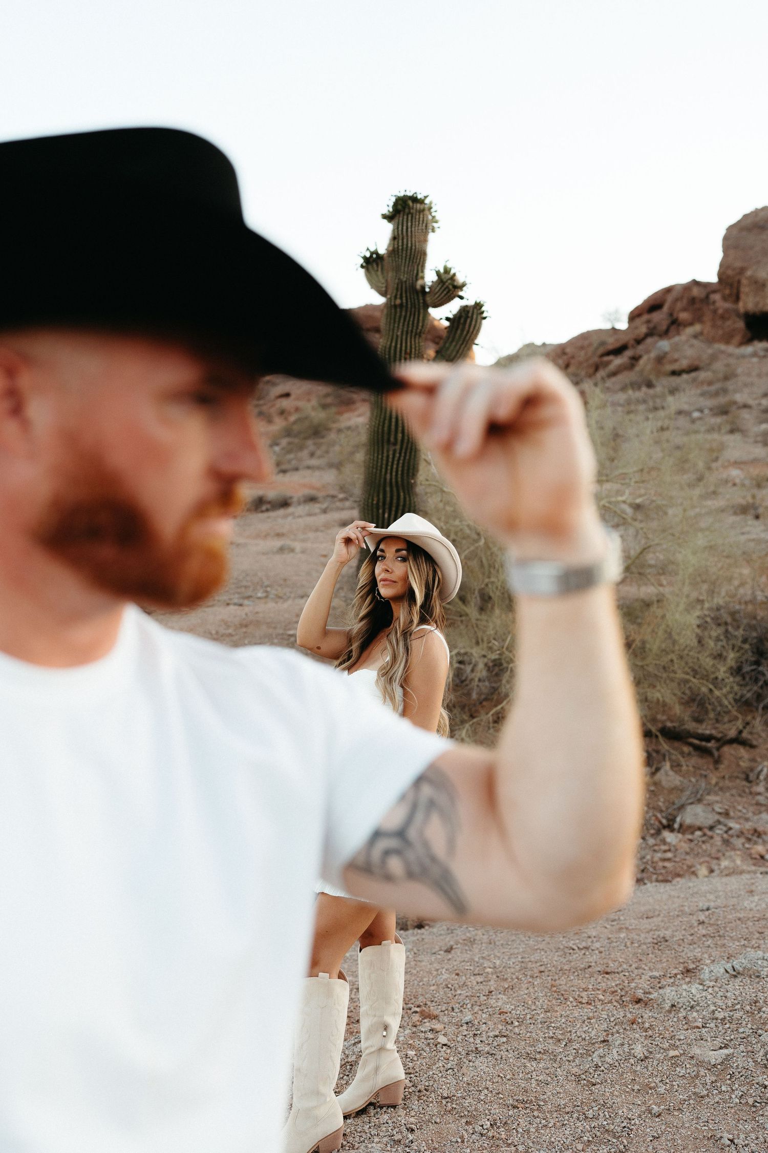 Series of photos captured from behind showing someone aiming a camera in a desert with cactus and rocky terrain.