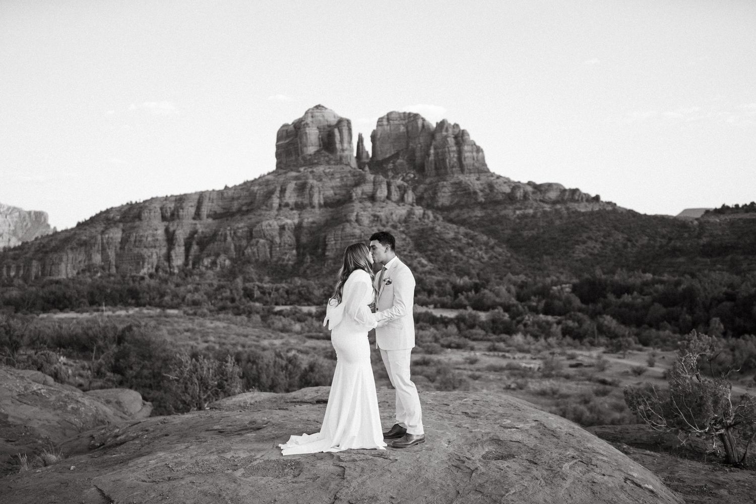 Black and white wedding portrait with majestic mountain backdrop.
