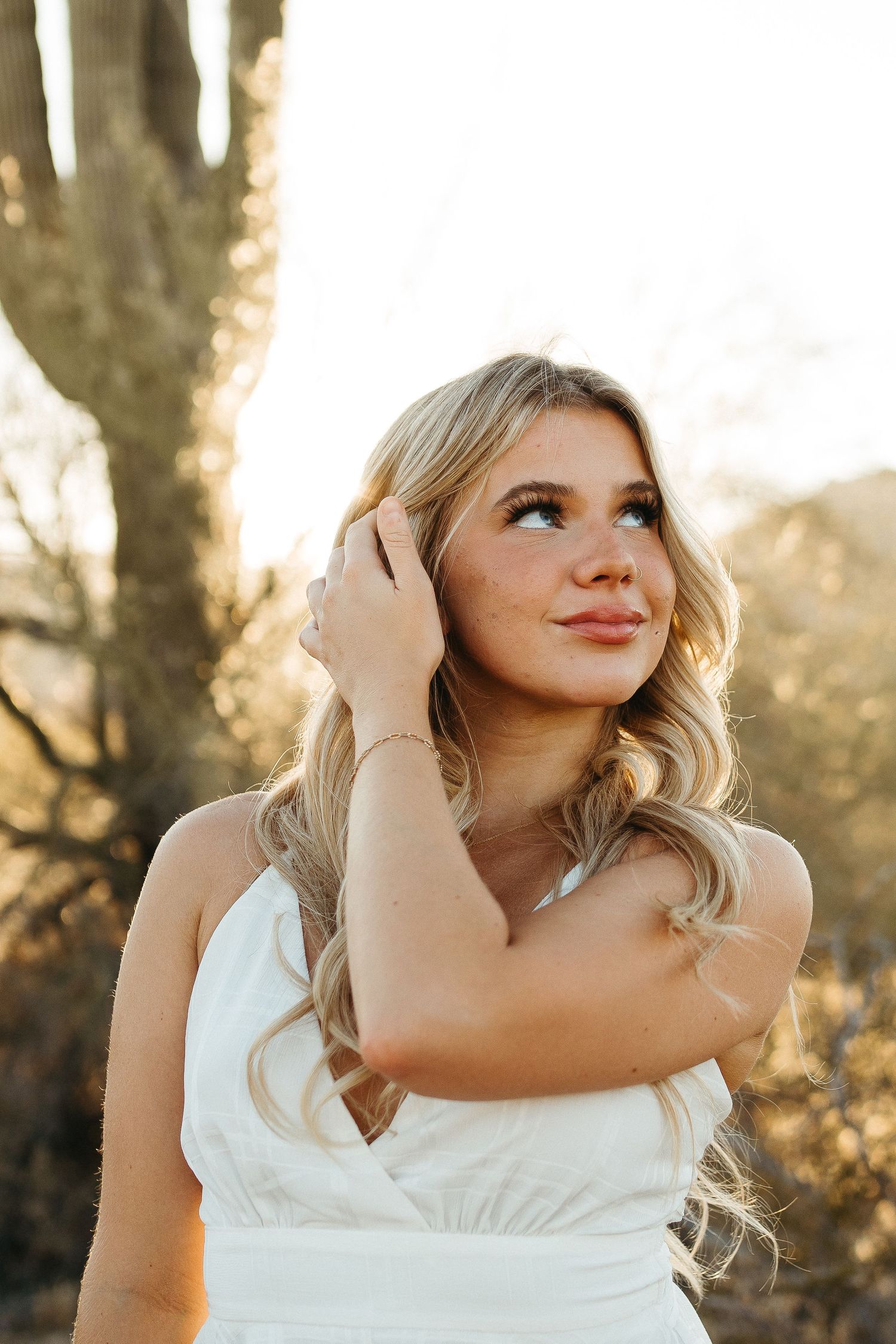 Outdoor portrait against desert backdrop with saguaro cactus and golden sunlight.