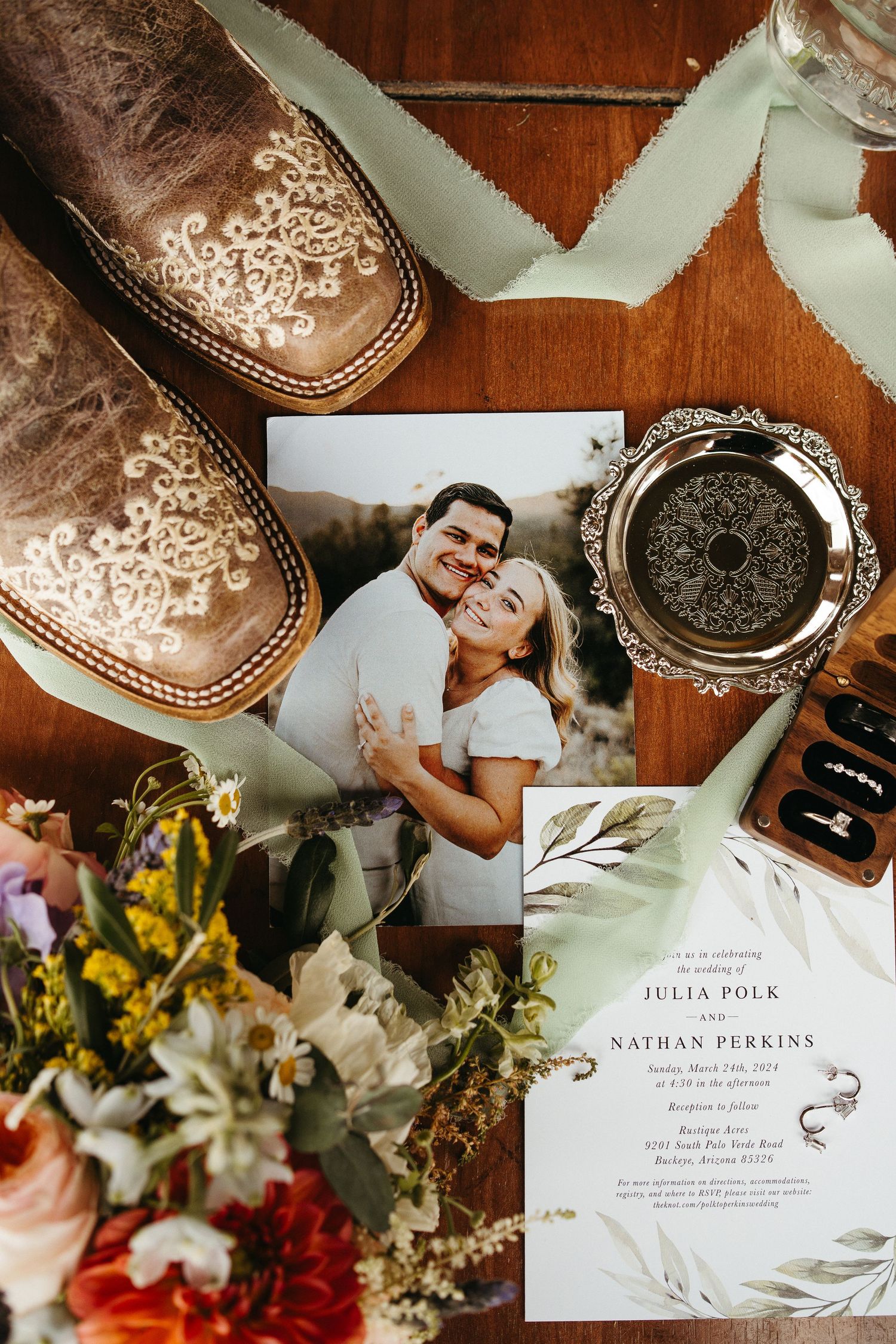 Wedding invitation with boots, flowers and decorative details in rustic styling.