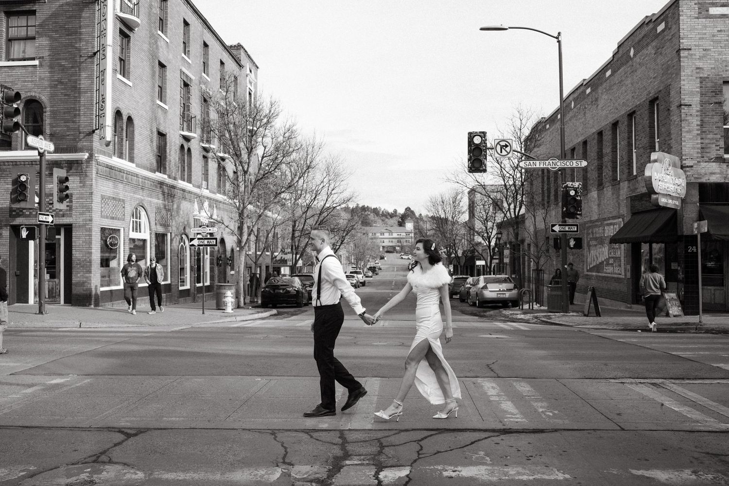 A couple dances joyfully in the middle of a city street intersection.