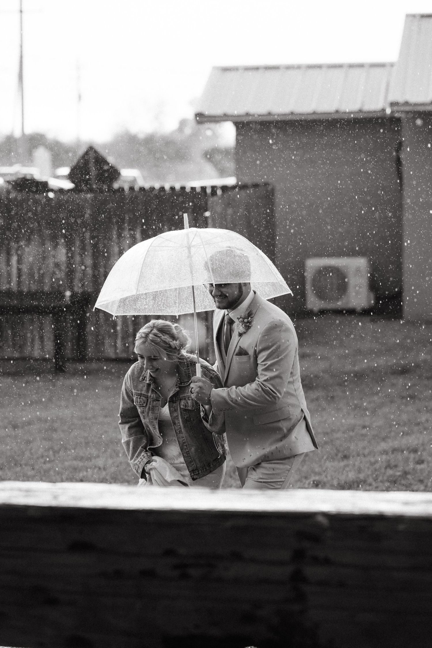 A black and white photo of two people sharing an umbrella in the falling snow.