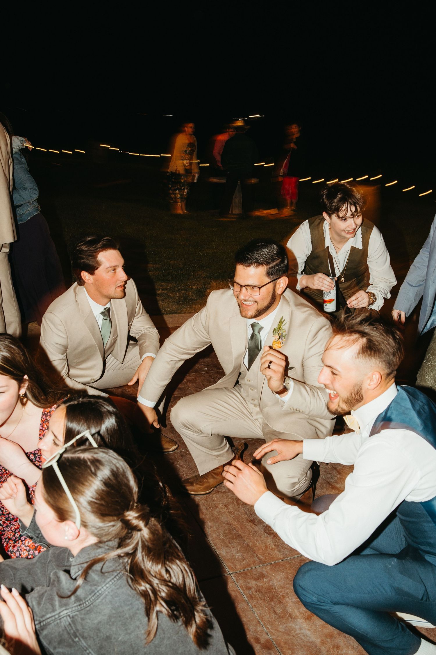 Wedding guests gathered in a circle on the dance floor during reception celebrations.