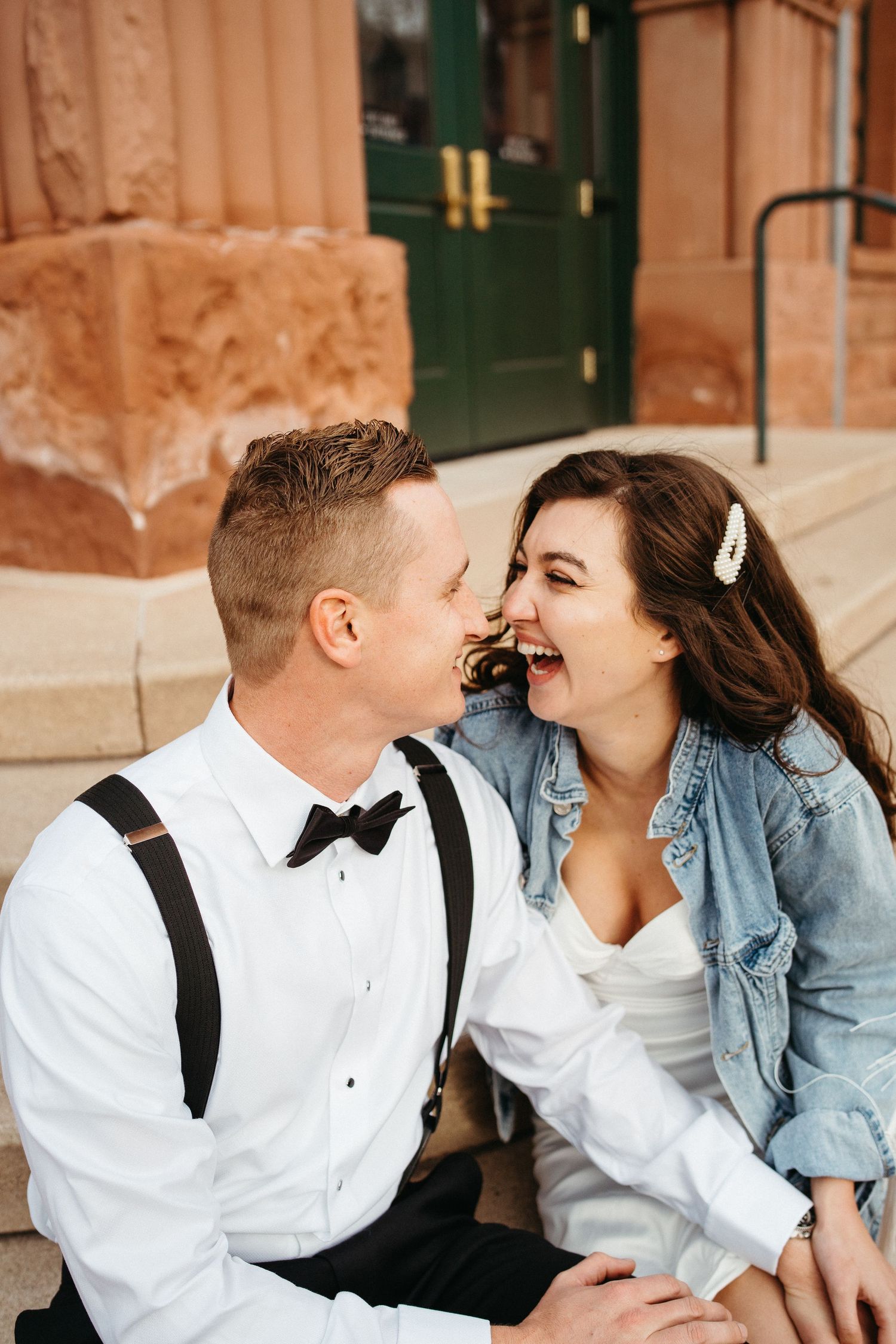 A joyful moment shared on the steps of a historic building with arched doorways.