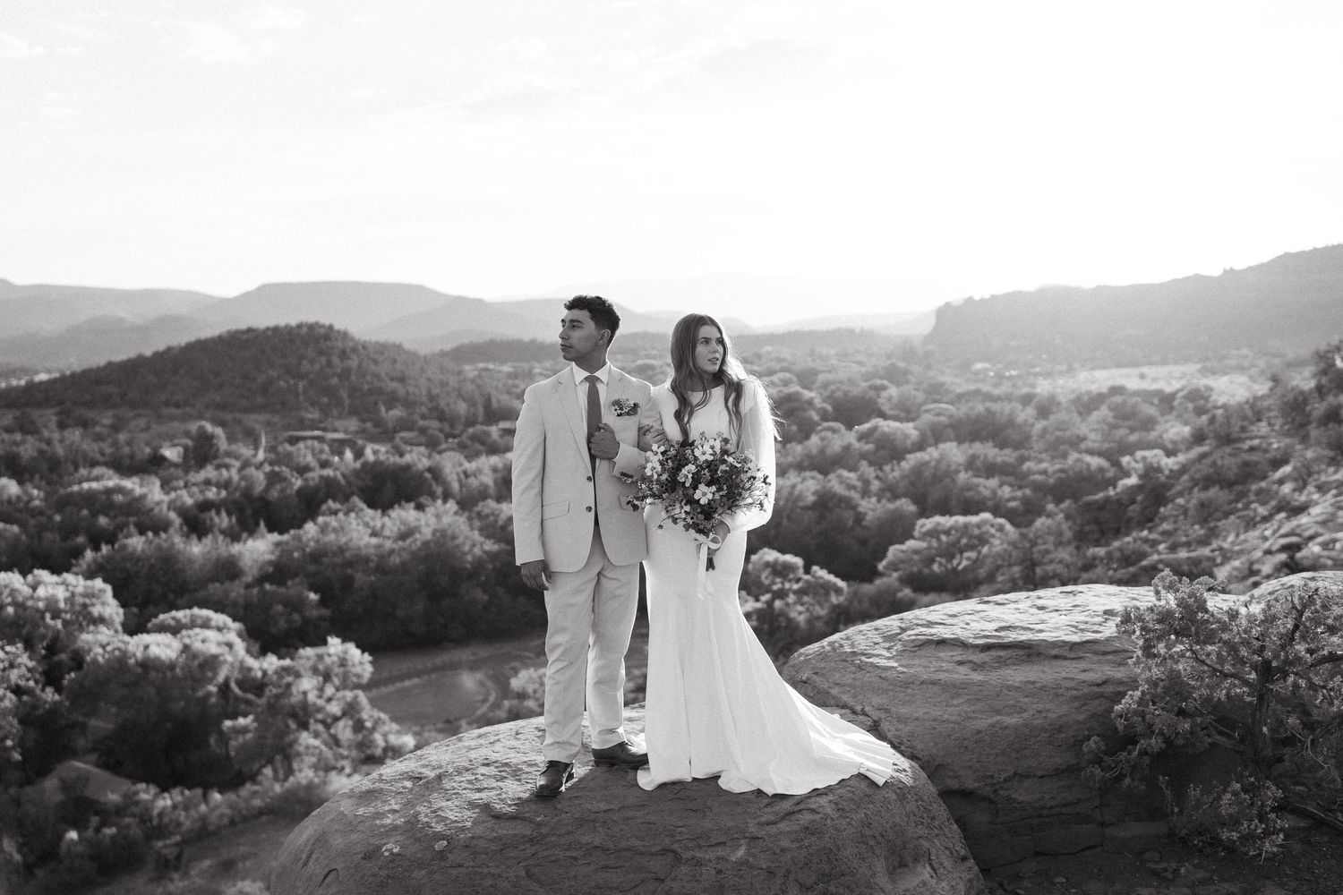Black and white landscape portrait of couple on desert overlook.