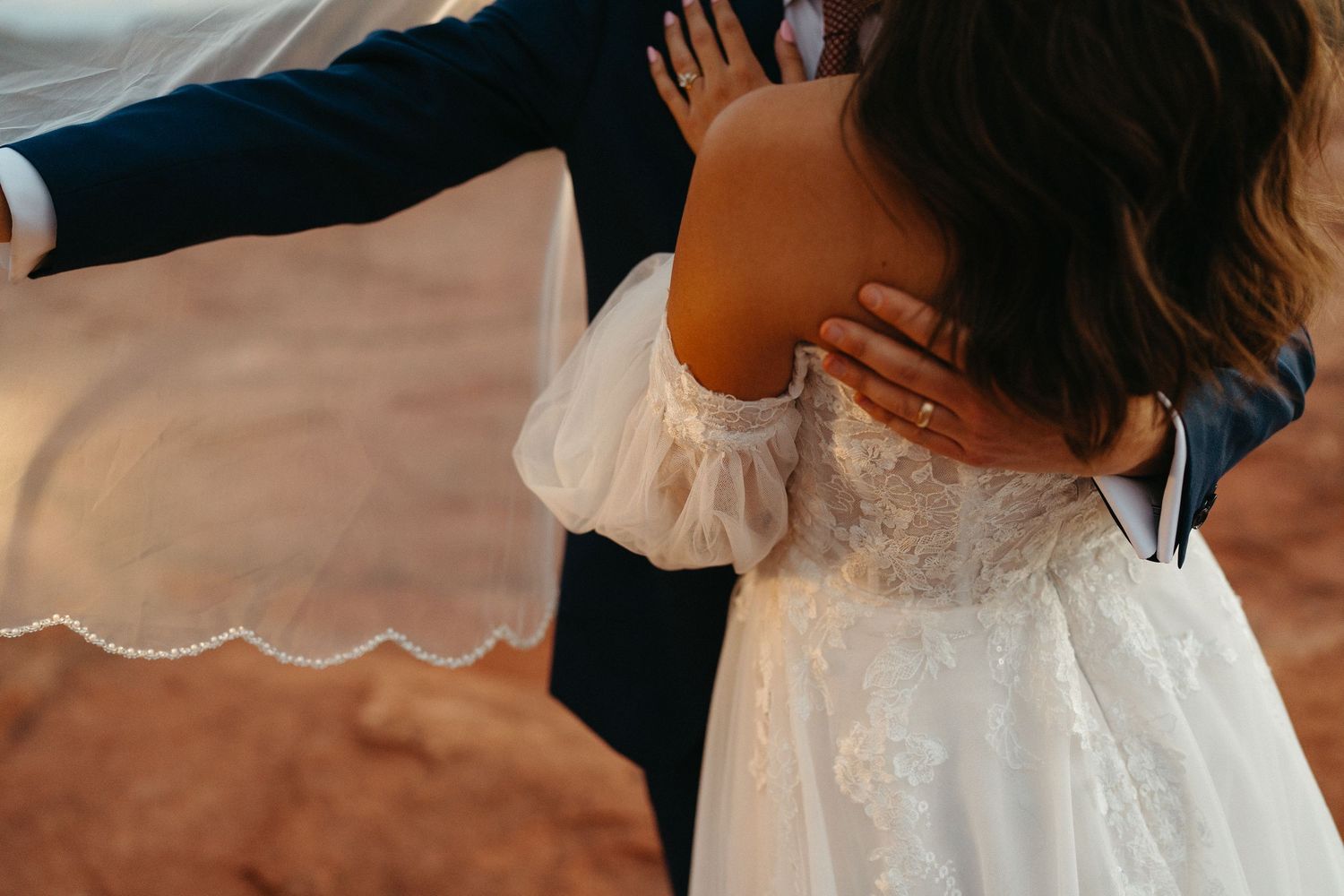 A couple shares a tender moment during their wedding ceremony while exchanging rings.
