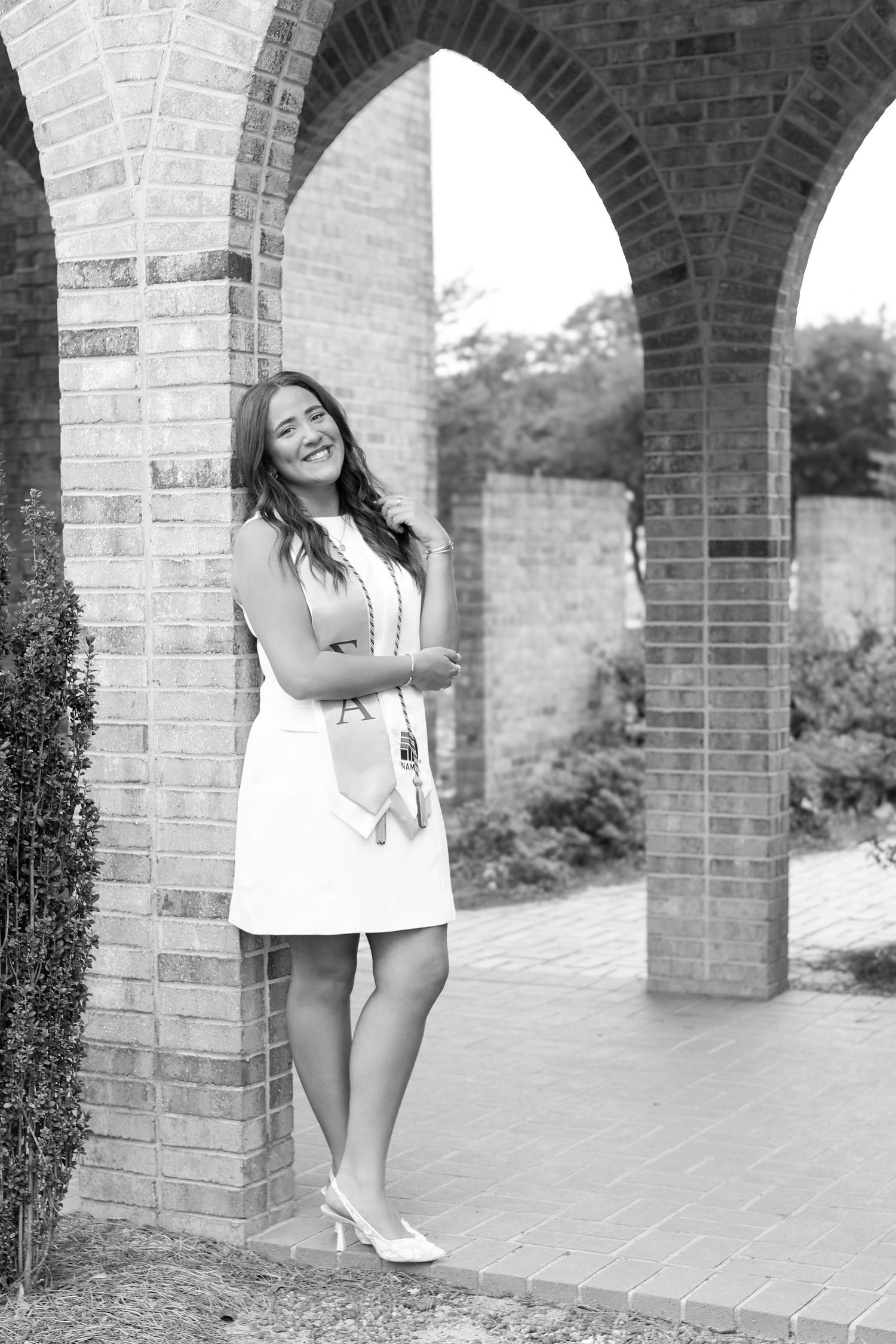 Graduation portraits captured under brick archways with natural lighting.