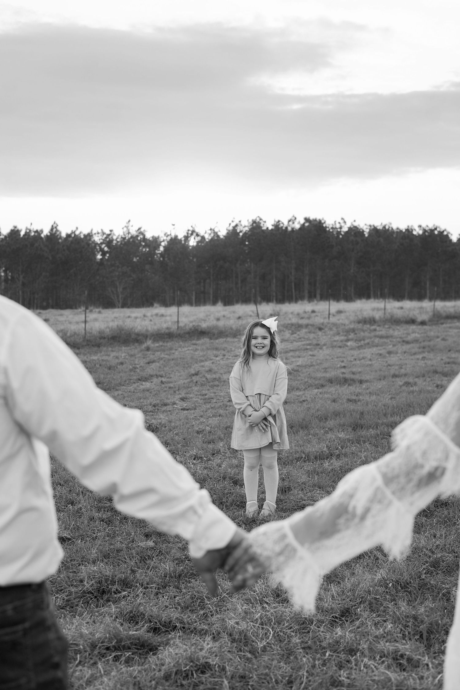 Series of monochrome images showing playful moments in a rural field with trees in the background.