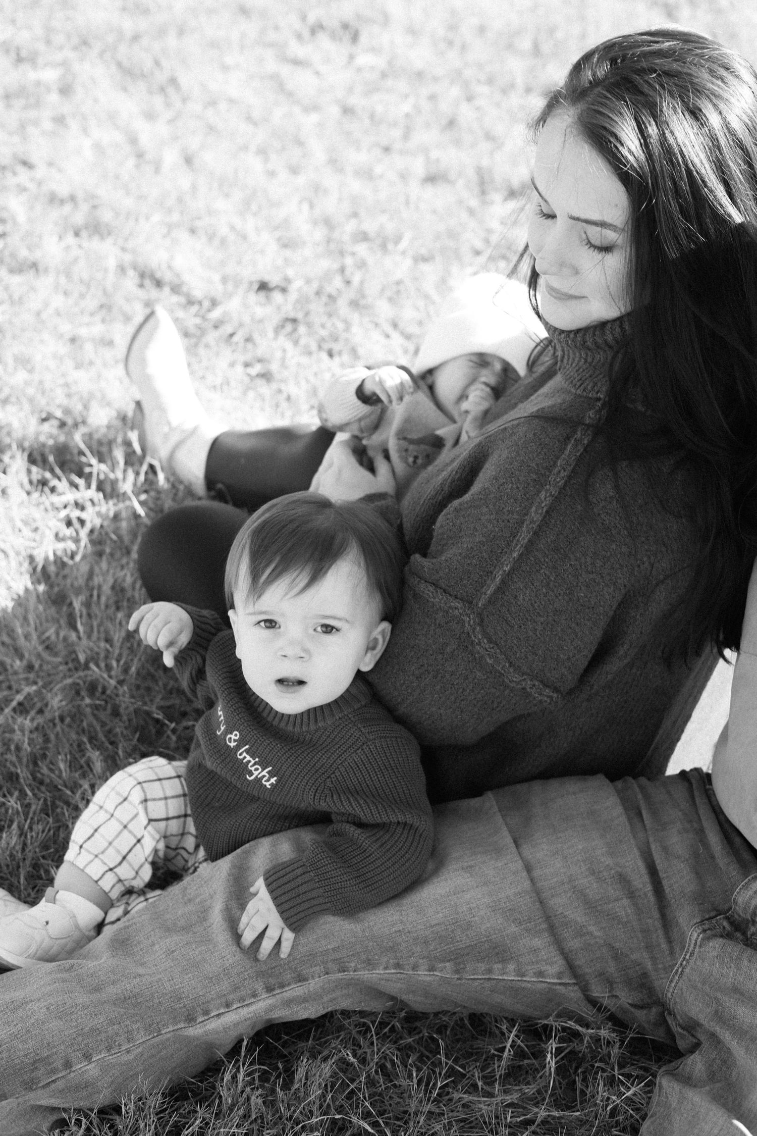 A black and white photo series showing tender moments between a parent and baby relaxing together outdoors.