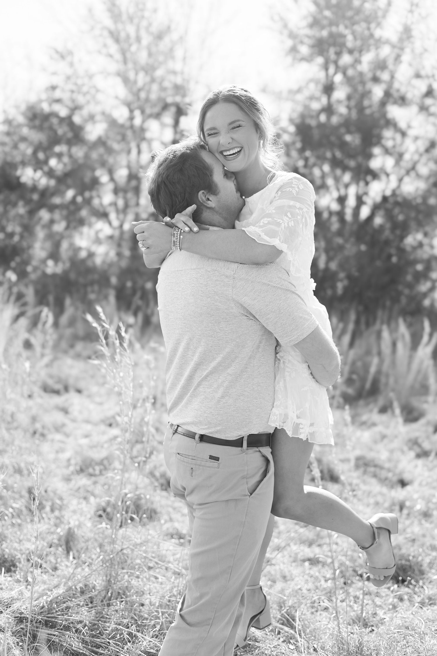 Multiple romantic black and white photos of couples sharing tender moments in a natural outdoor setting.