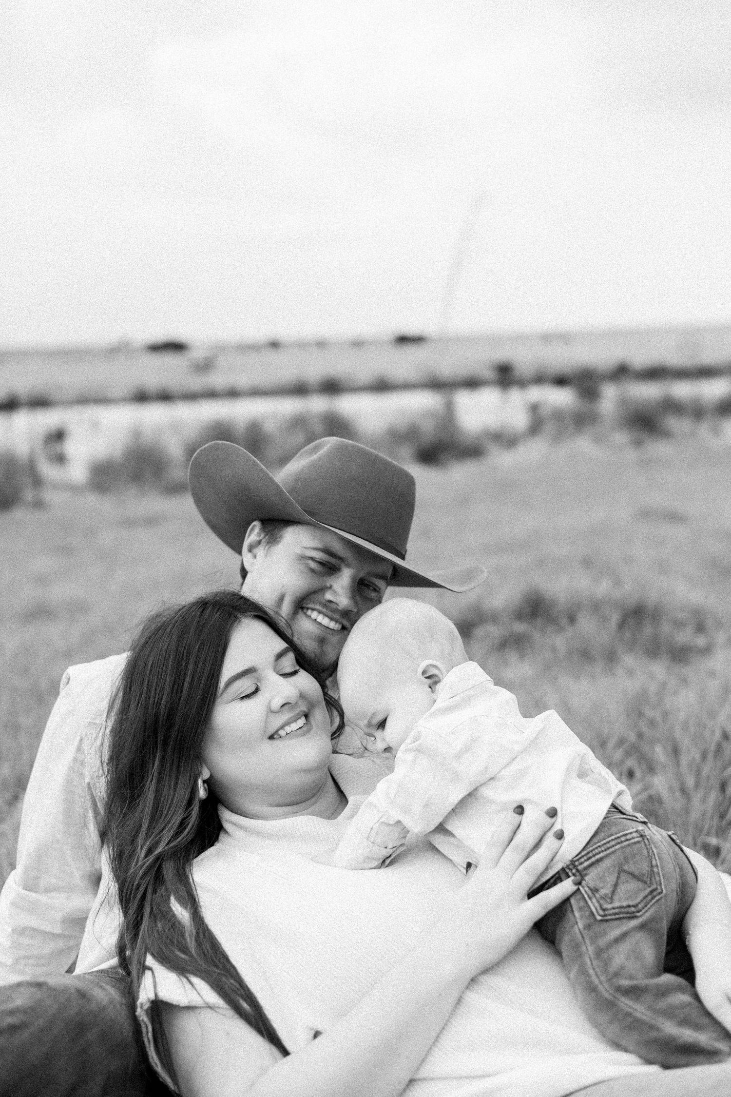 A family sharing an intimate moment while relaxing outdoors in black and white.