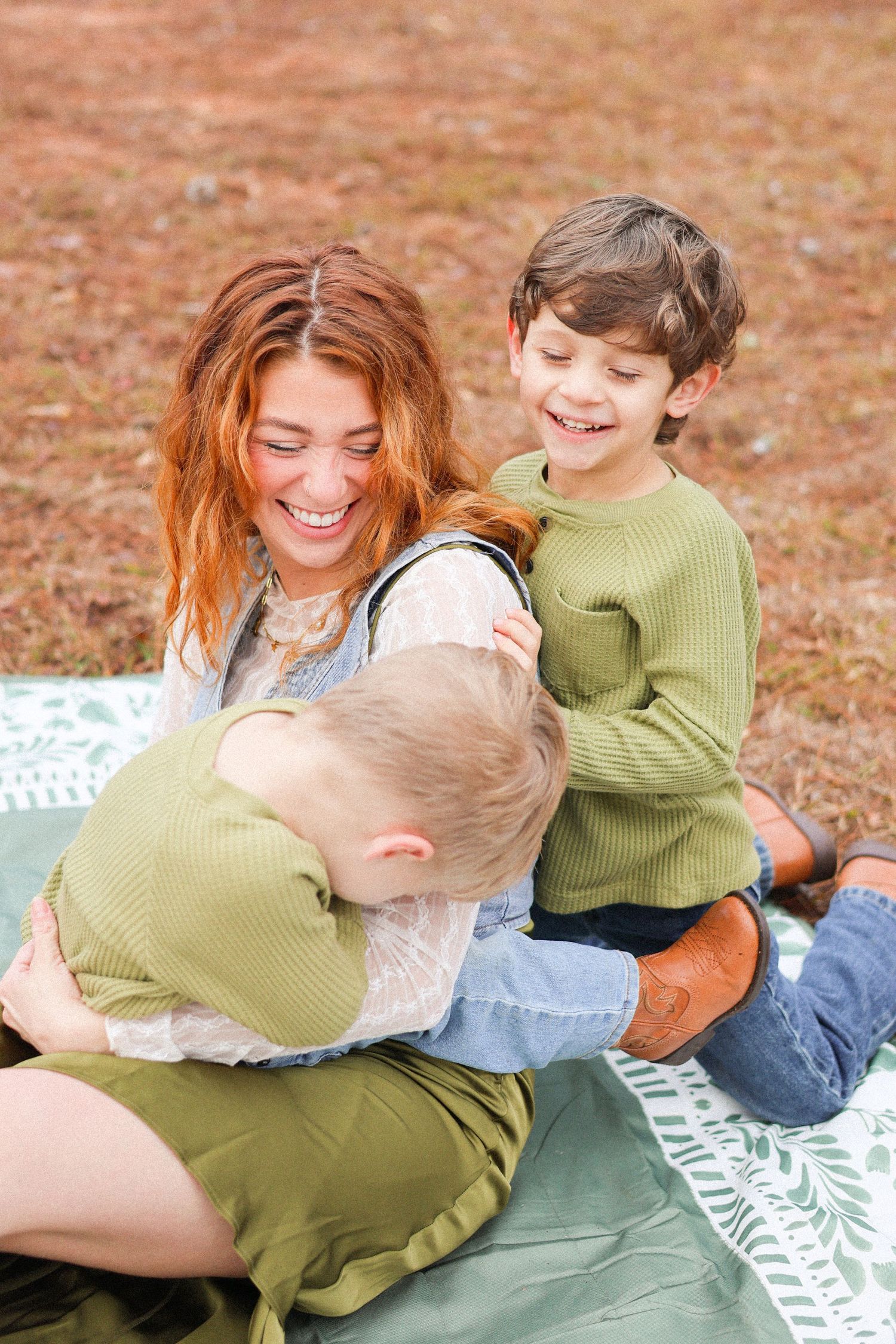 A pair lounges on a blanket in autumn, sharing joyful and intimate moments together.