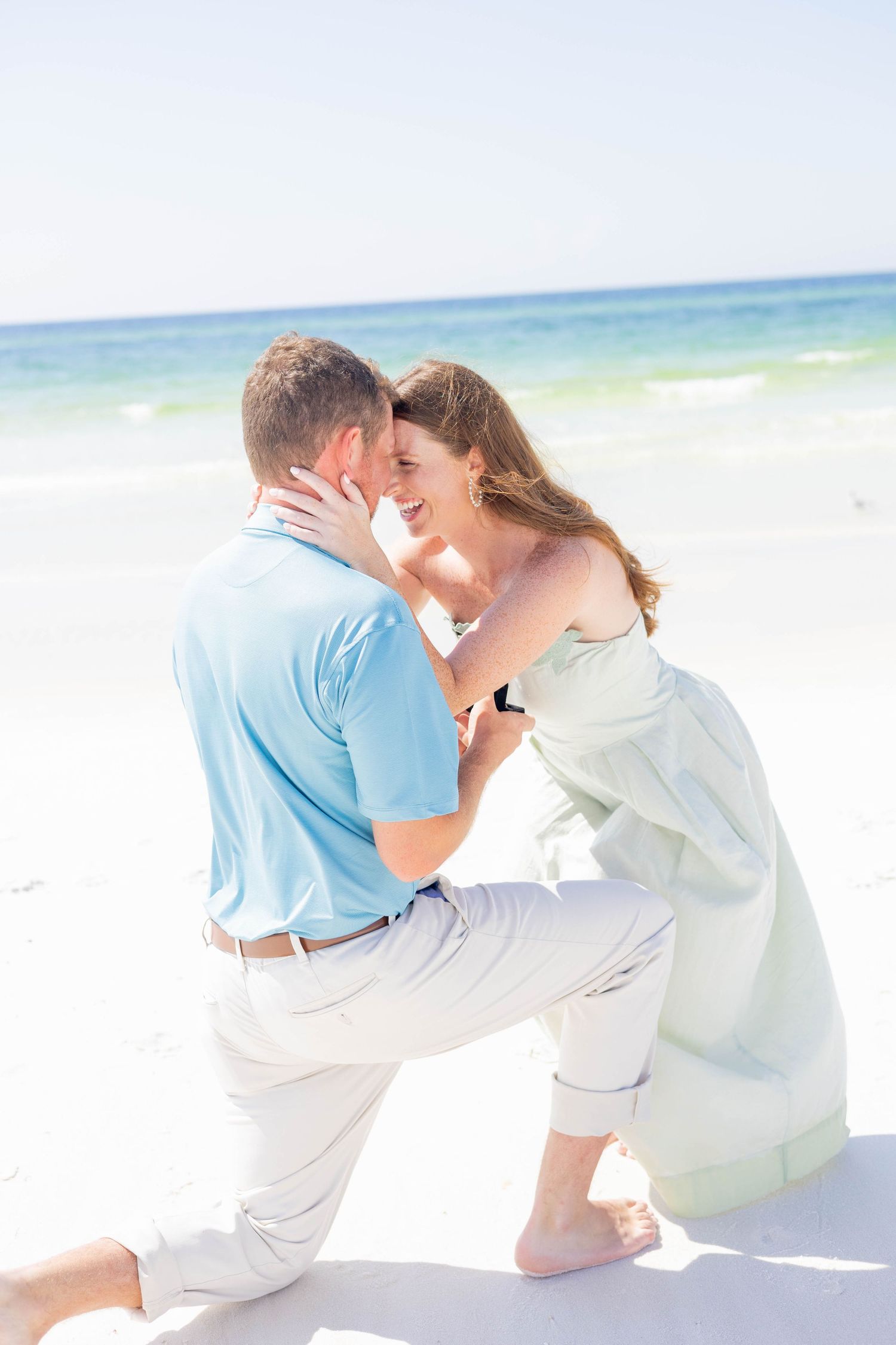 Romantic beach photoshoot sequence with couple in light colored clothing by the ocean.