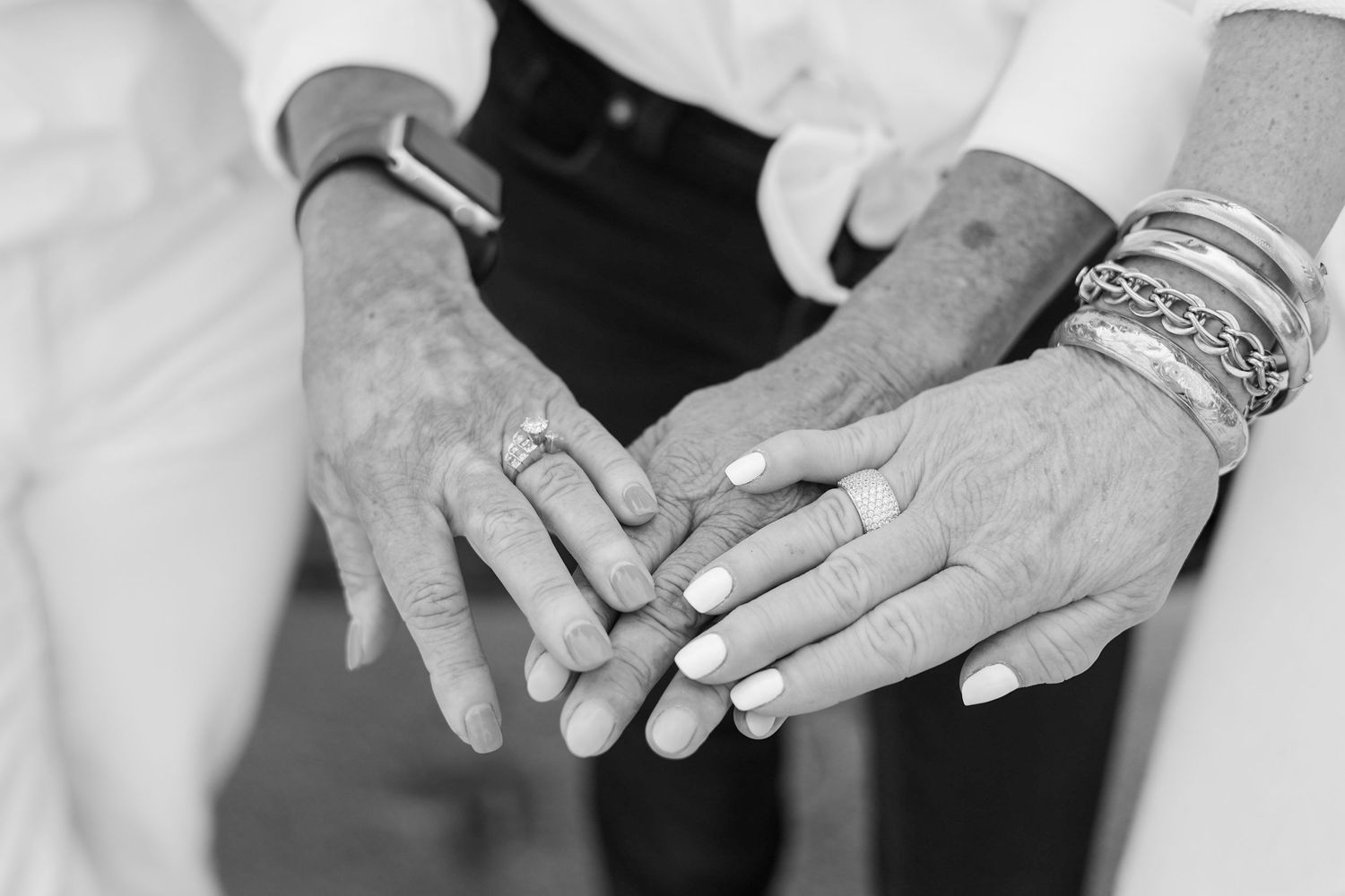 Close-up black and white photos showing hands with wedding rings in various poses.