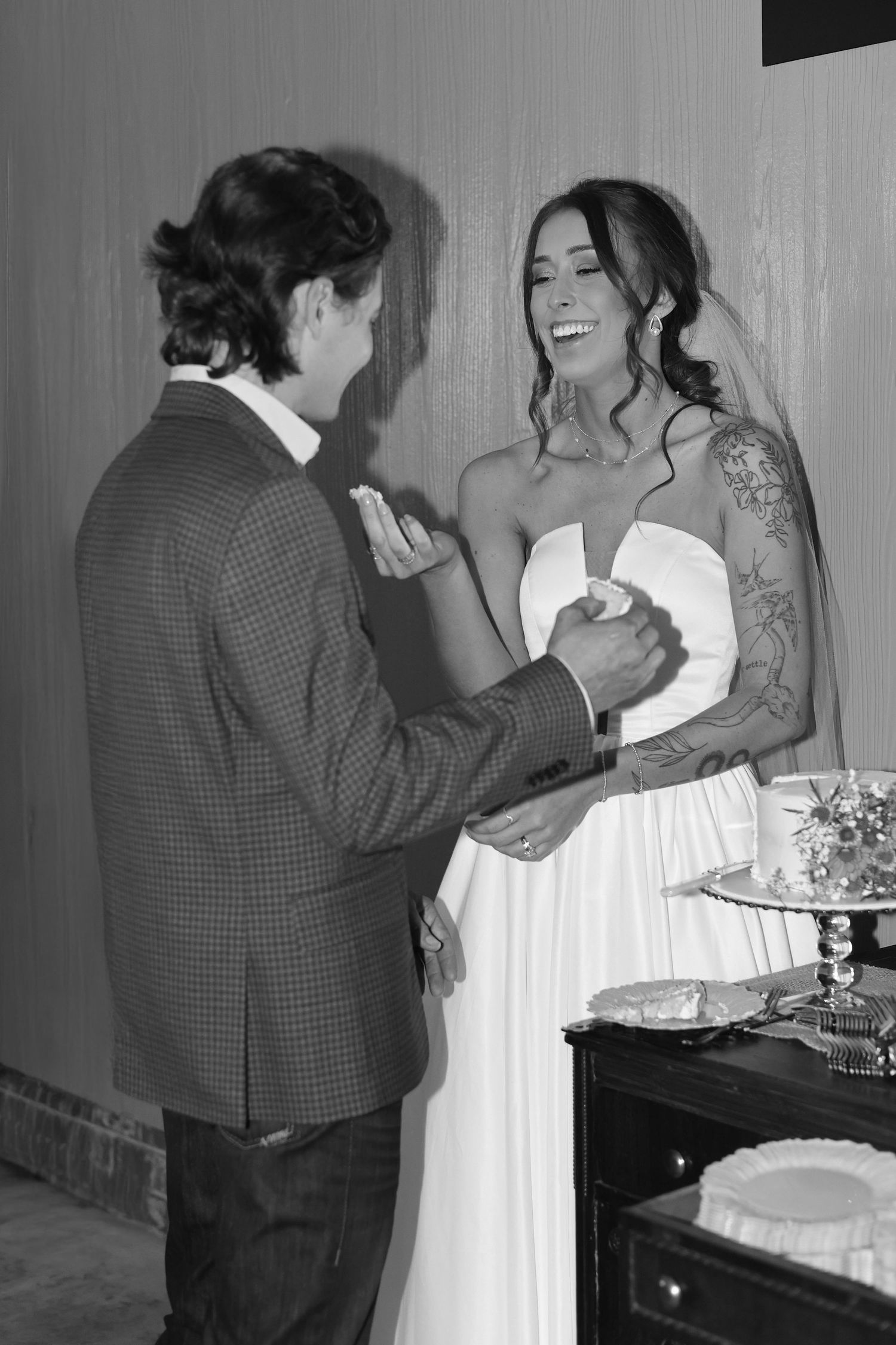 Black and white sequence showing a couple sharing cake during their wedding reception.