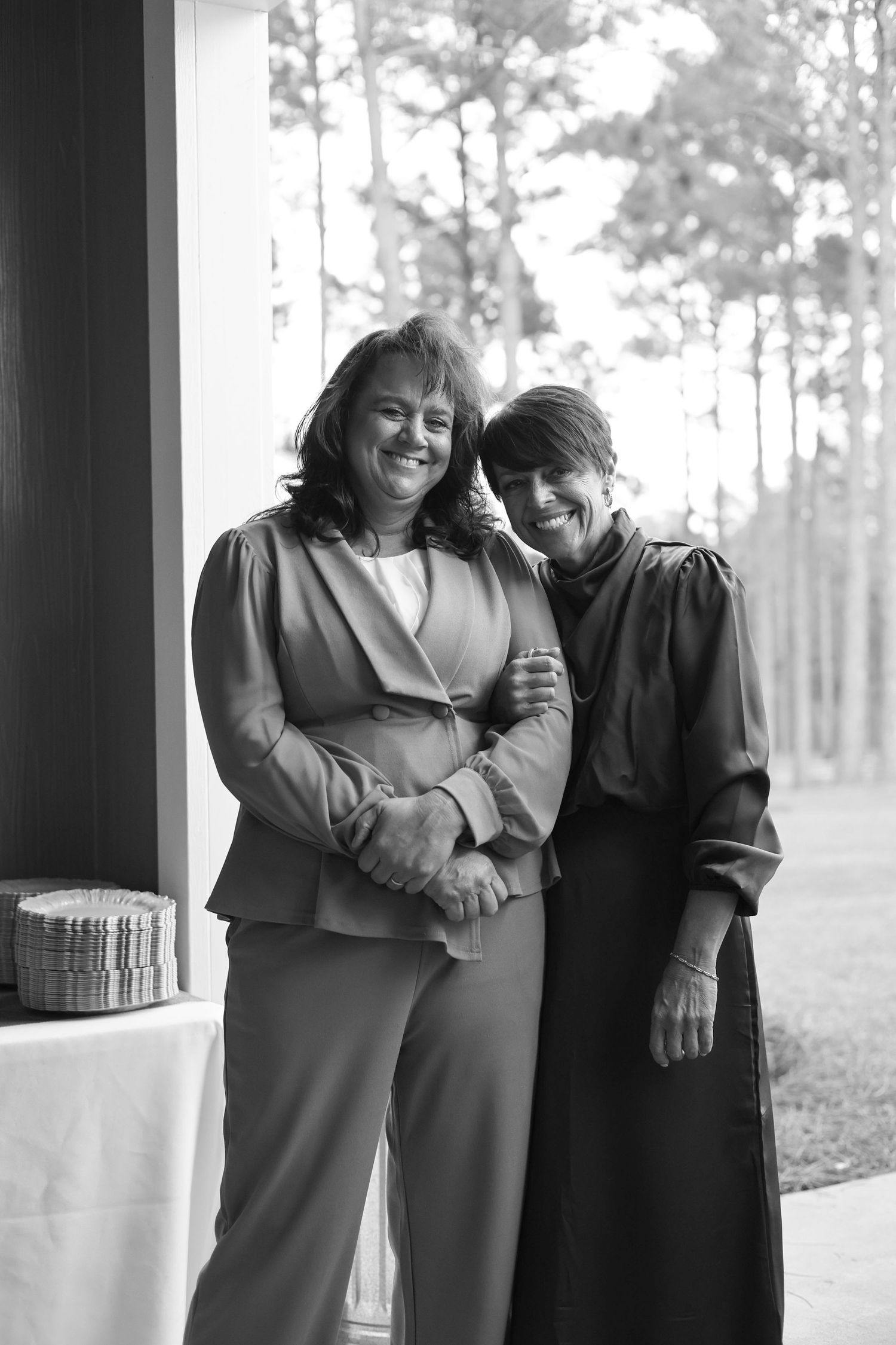 Black and white portrait of three people sharing a joyful moment.