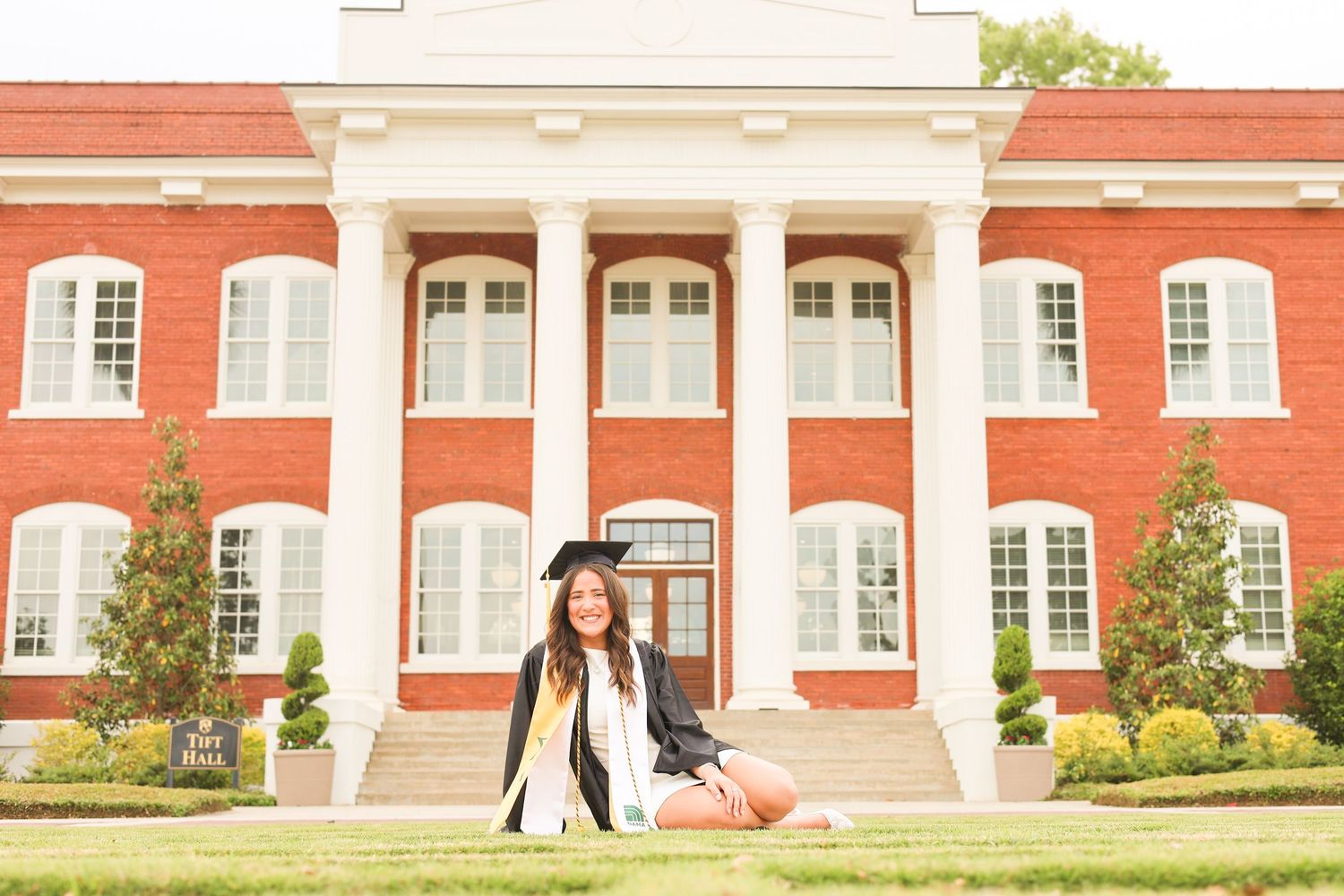 Wide architectural shot of red brick university building with white trim and columns.