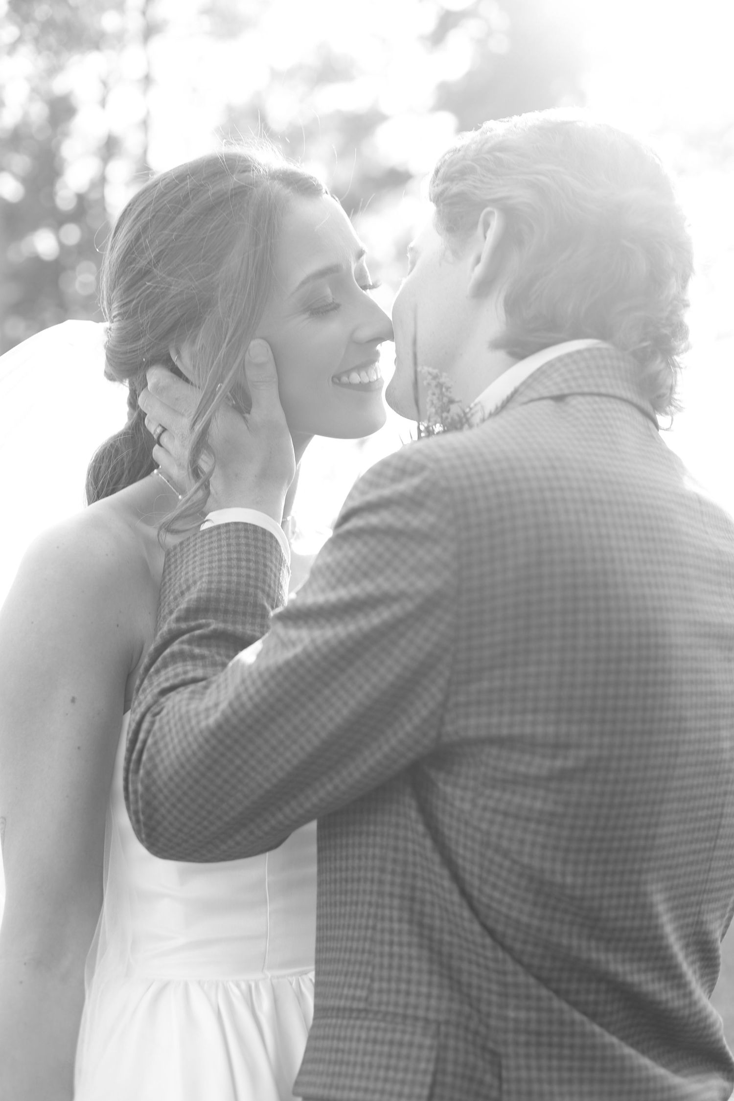 A black and white intimate moment captured during a wedding celebration.