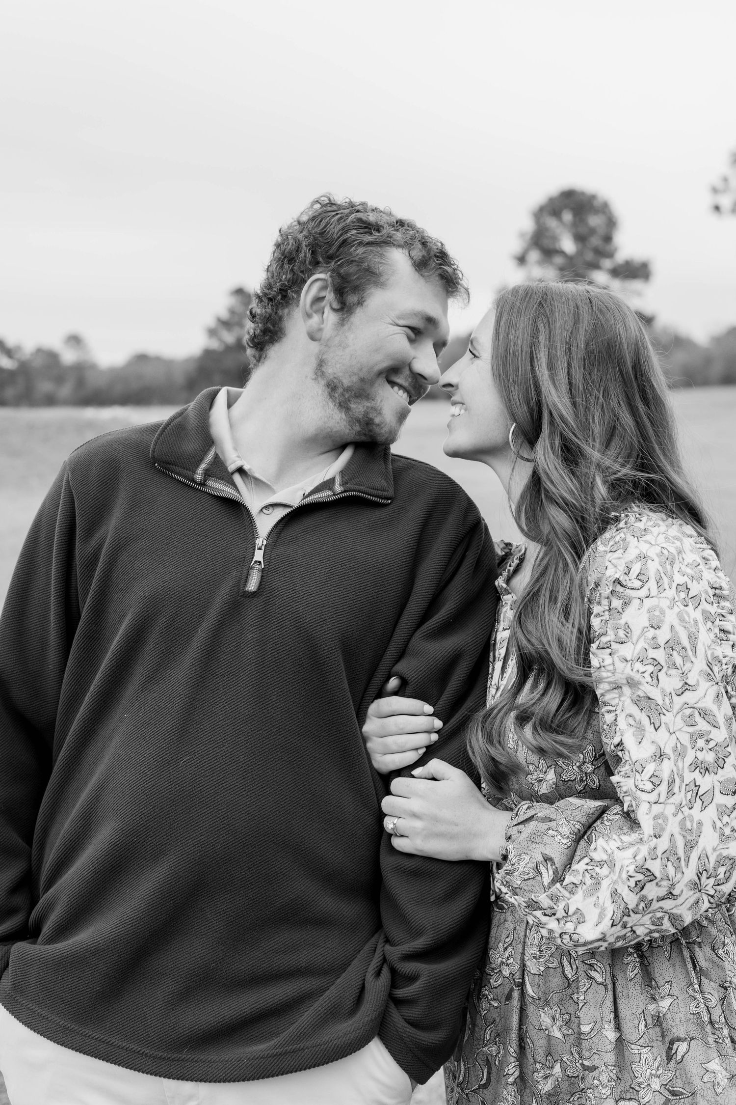 A couple shares intimate moments in a series of black and white photos outdoors.