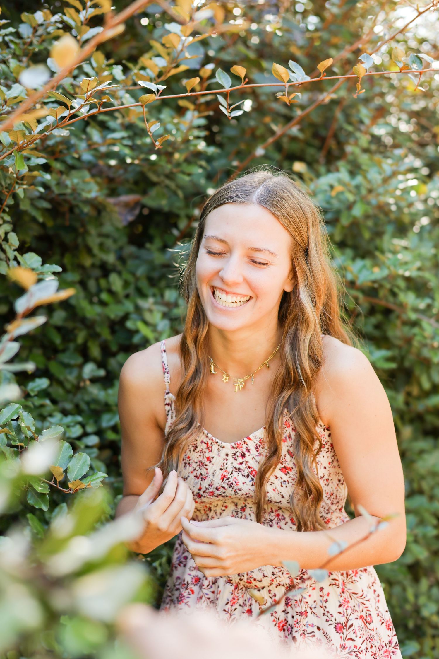 Candid portraits showing genuine laughter among green foliage.