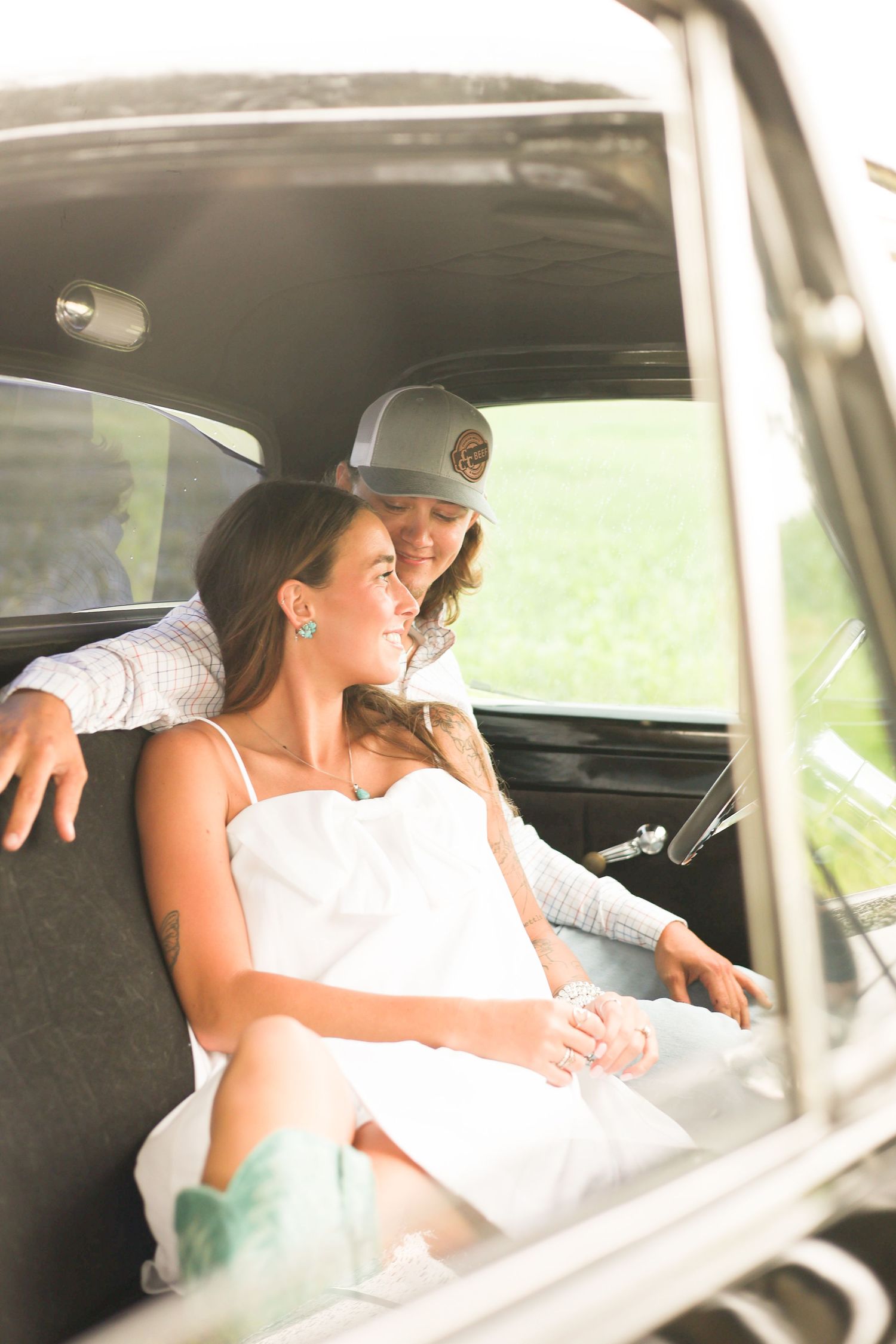 A romantic moment captured through a car window shows a couple in an intimate embrace.