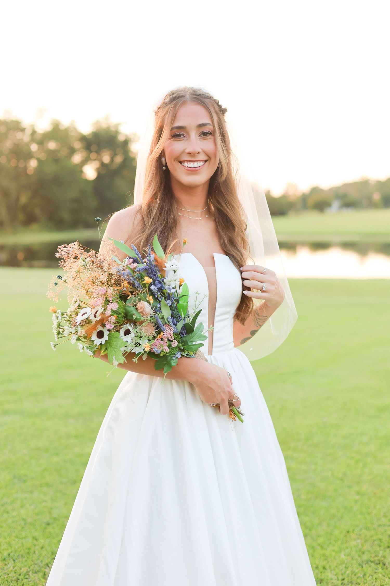 Candid bridal portraits with wildflower bouquet in natural outdoor setting during golden hour.