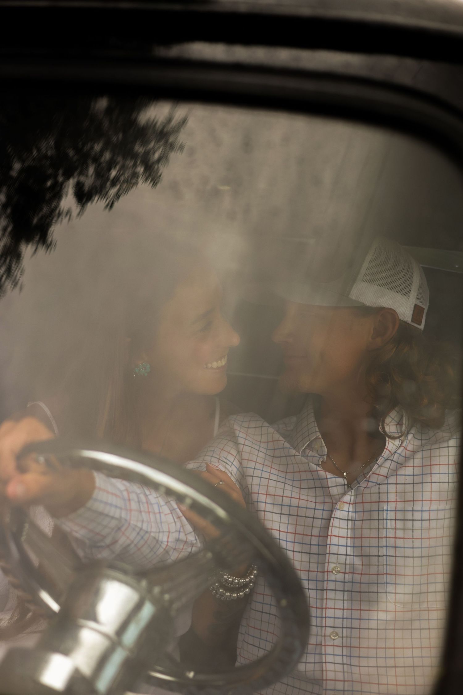 A silhouetted view through a car window shows two figures in an intimate moment.