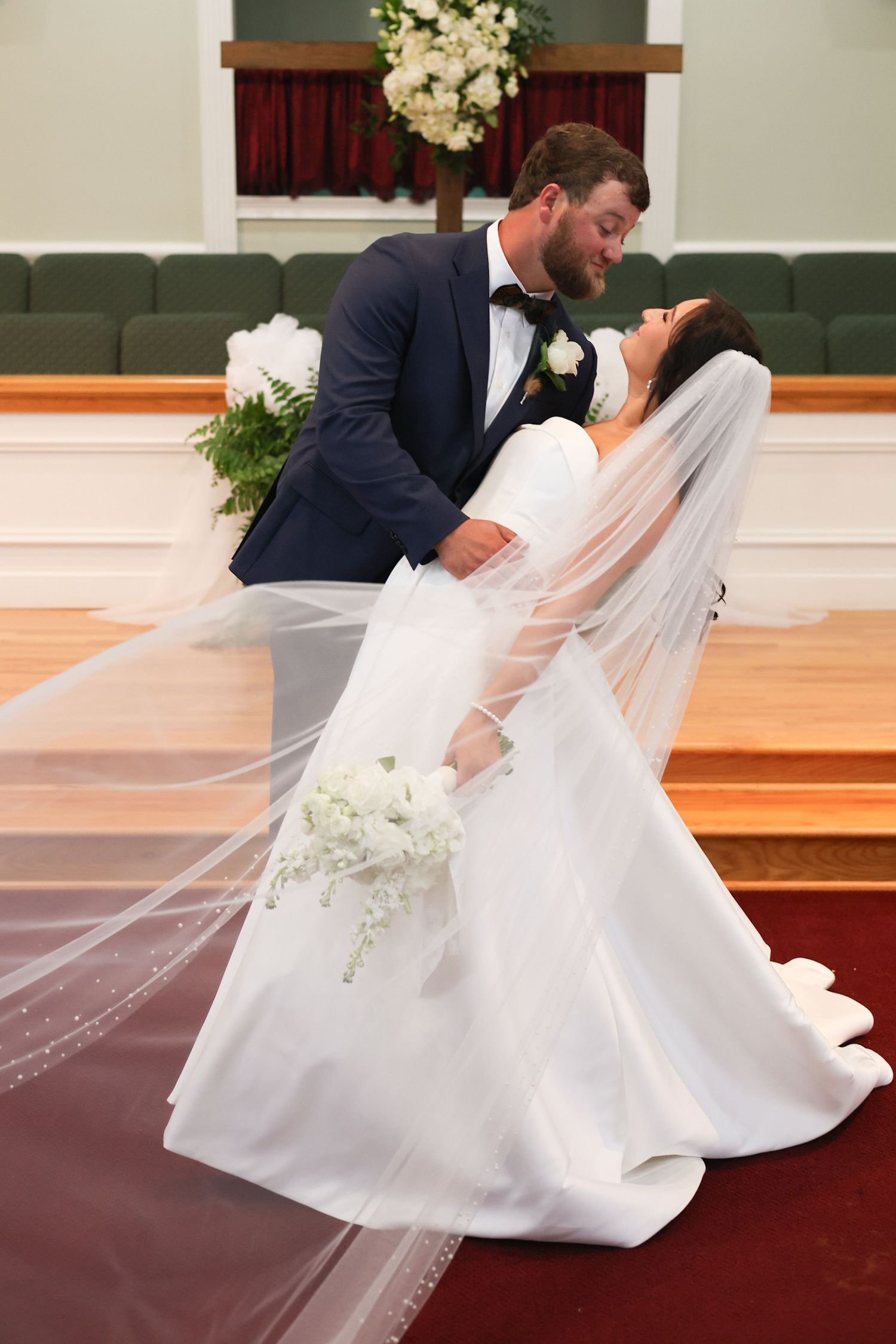 A romantic wedding dip pose sequence shows a couple in formal attire performing a graceful dance move in a church setting.