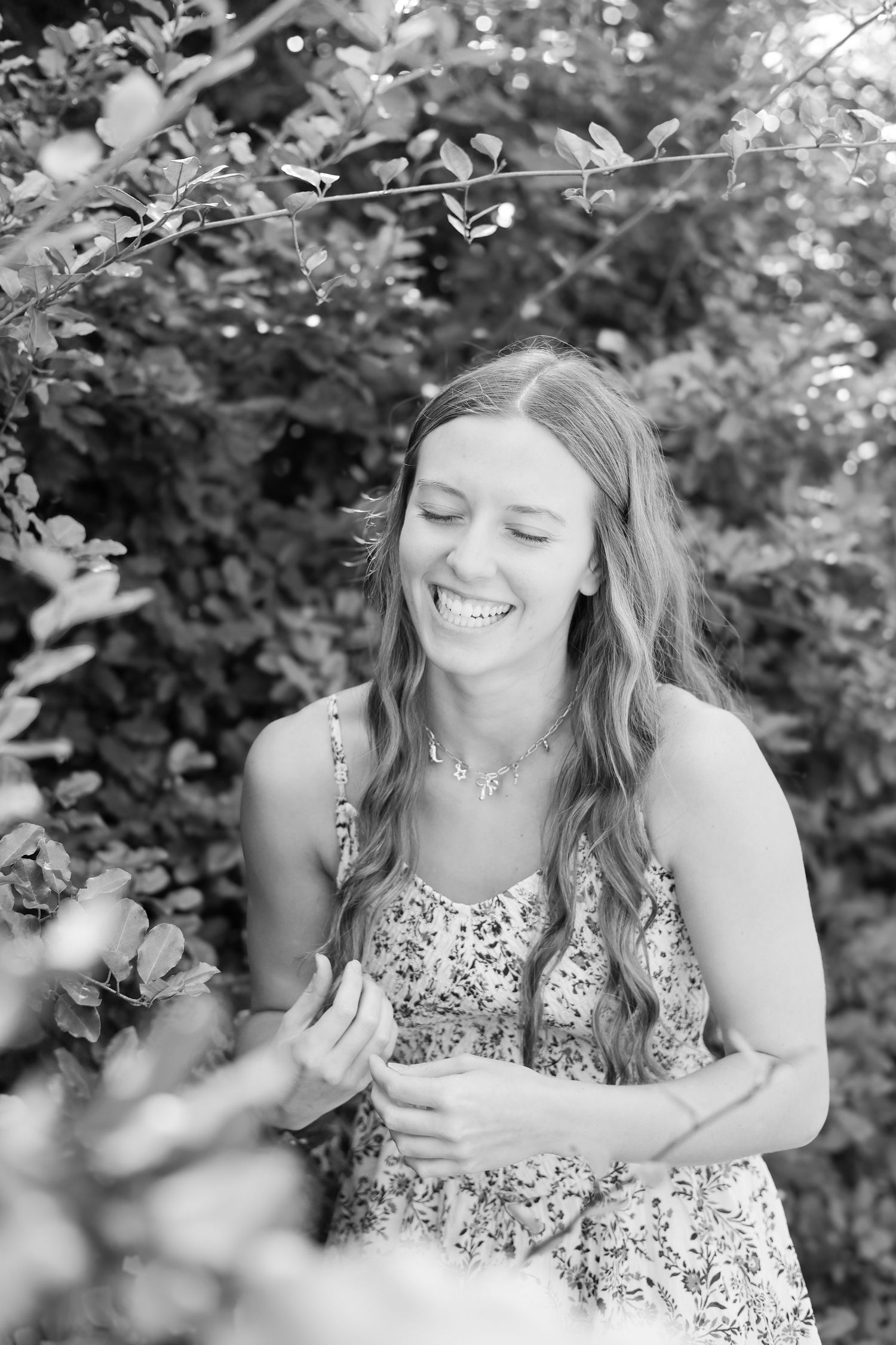 Black and white portrait series showing joyful expressions in natural setting.