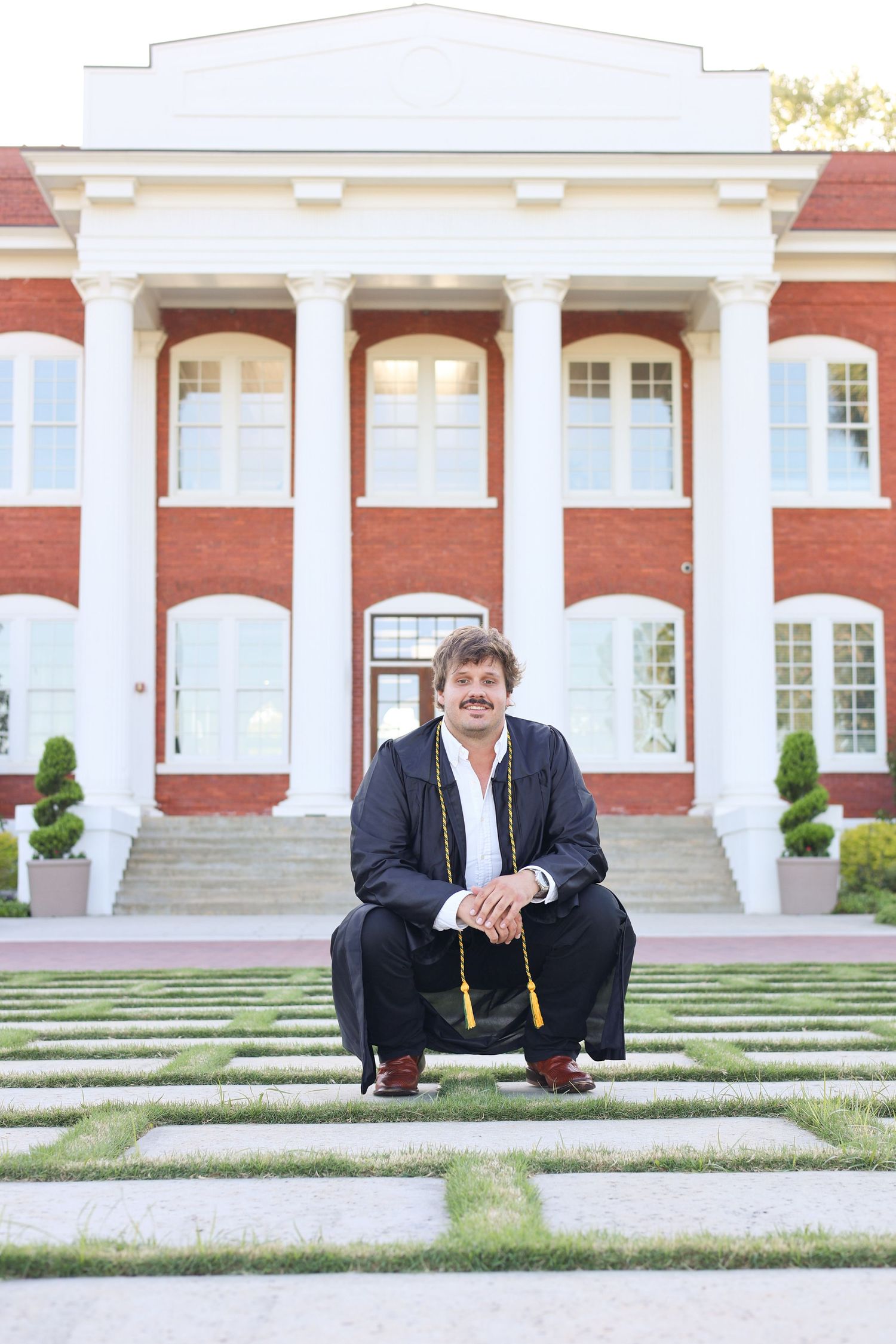 Casual senior photos taken on steps of traditional academic building.