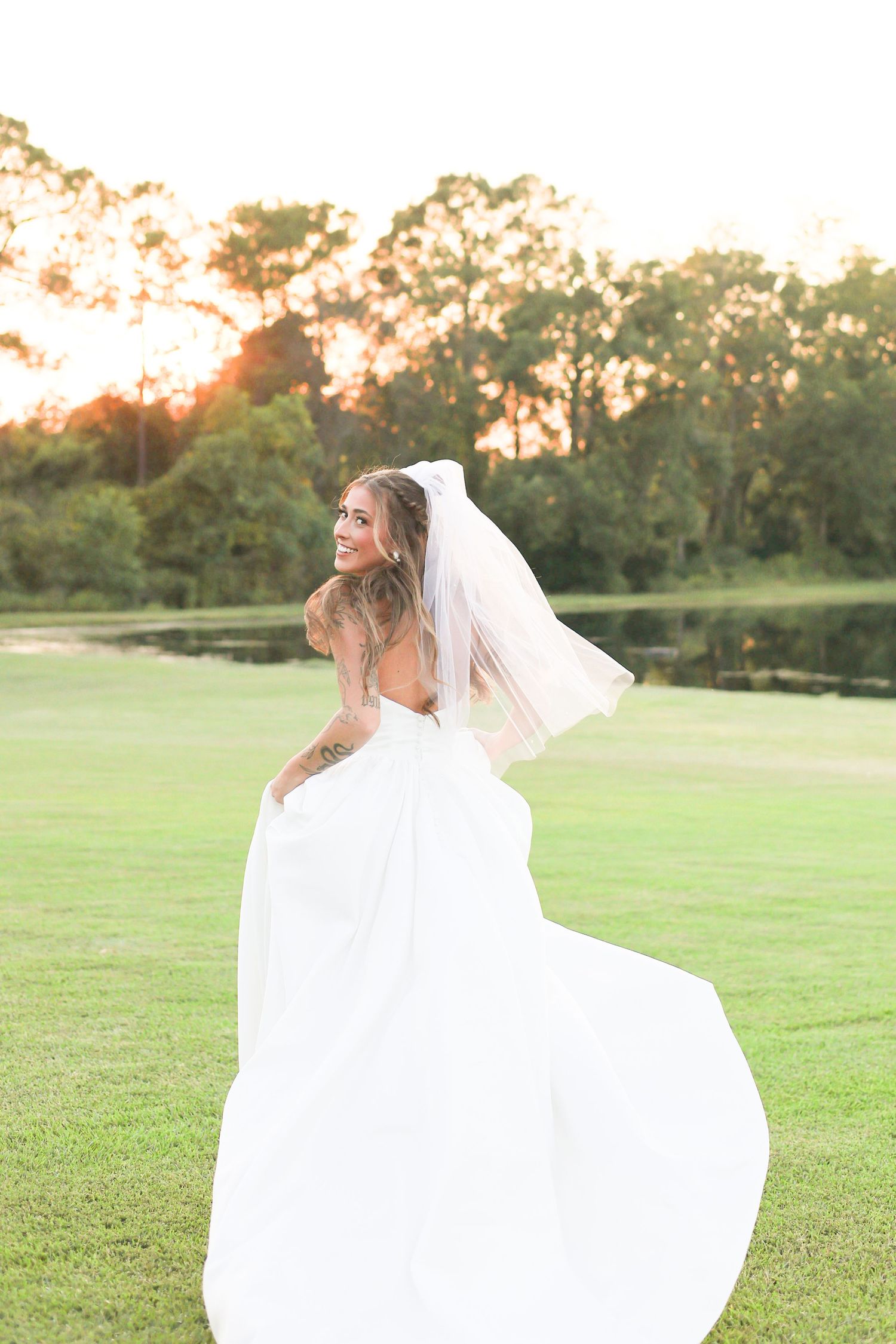 Romantic bridal series showing movement of white dress against sunset lit field.