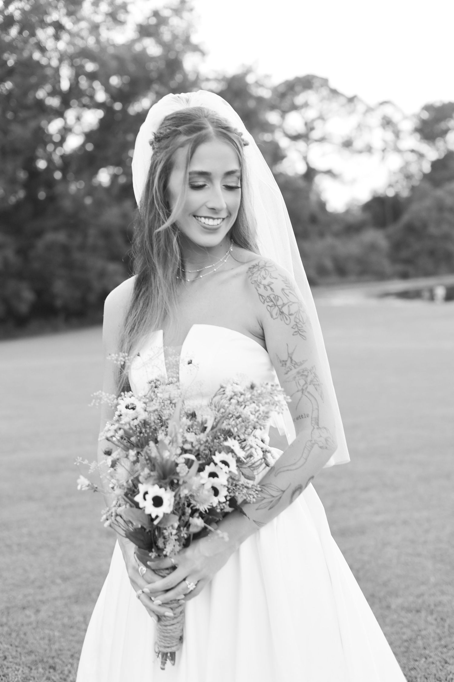 Black and white bridal portrait capturing joyful moments with a rustic bouquet.
