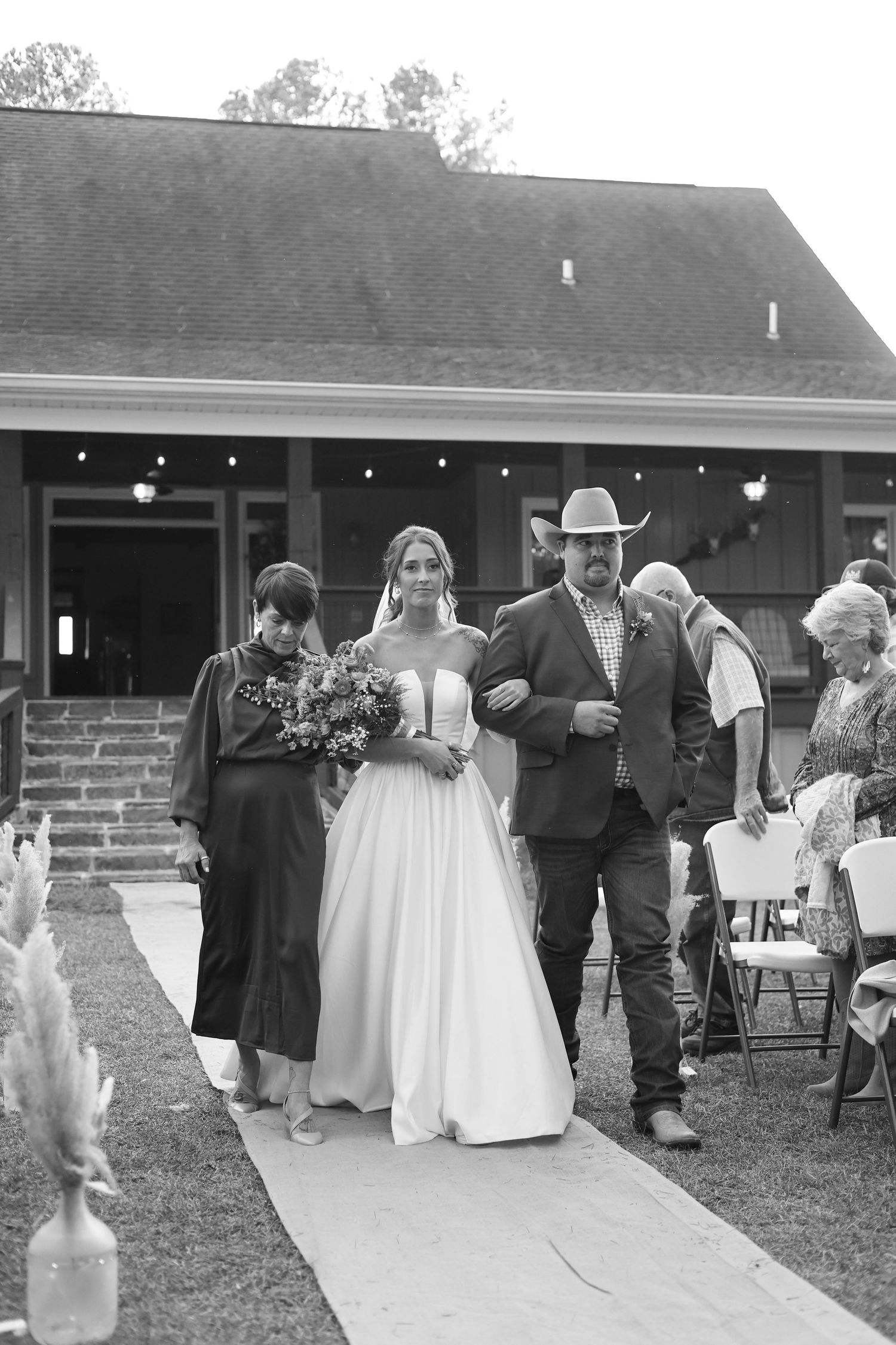 Wedding guests mingle outside a rustic venue during an evening reception.