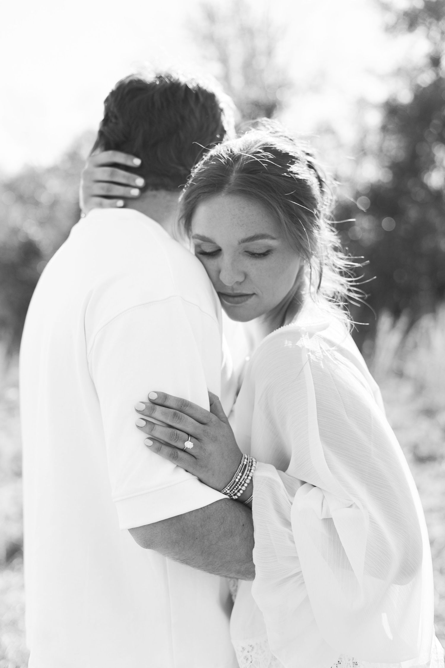Black and white portrait of couple sharing intimate moment in natural light.