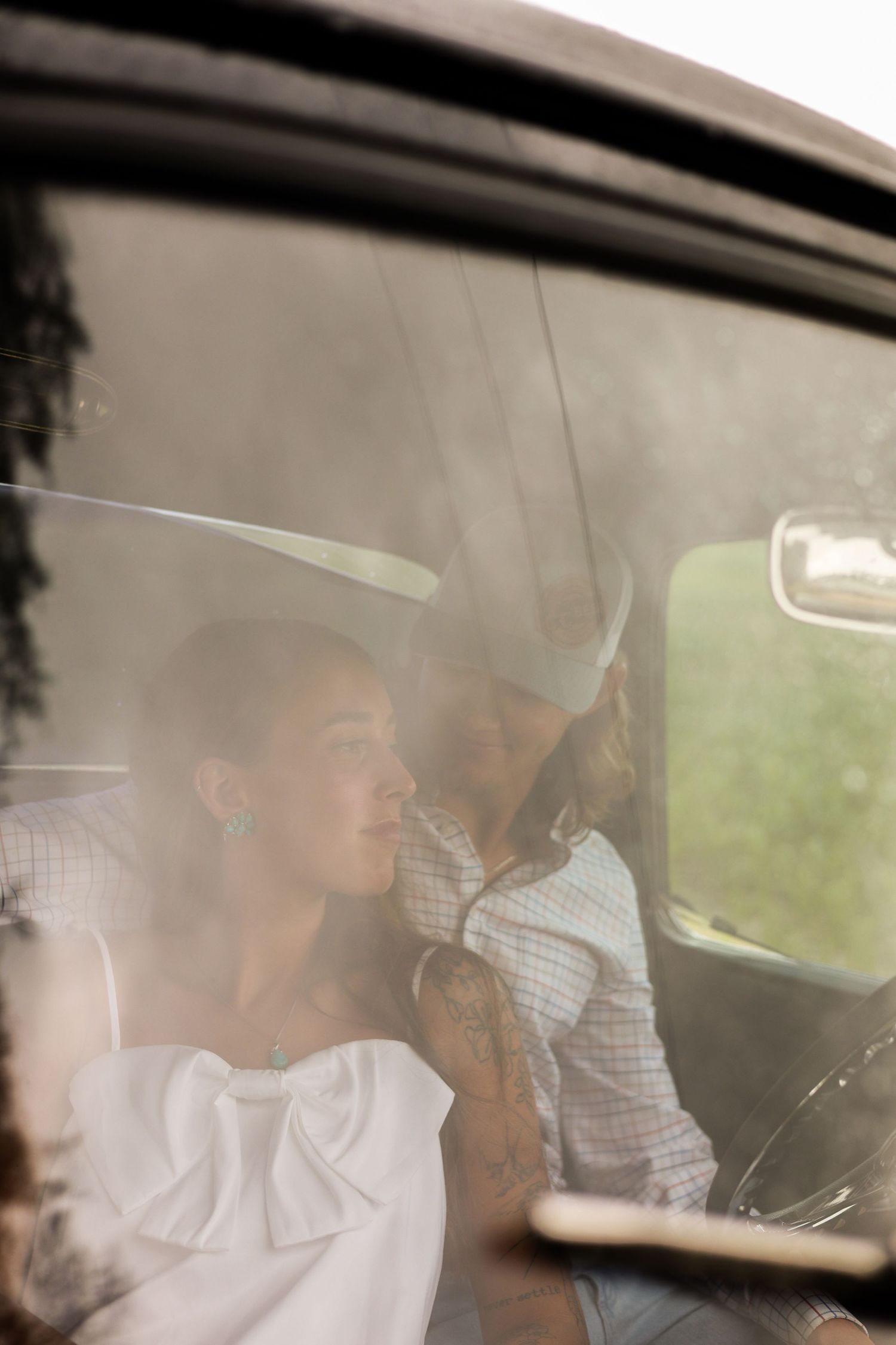 Soft light filters through car windows as a couple shares a tender moment inside.