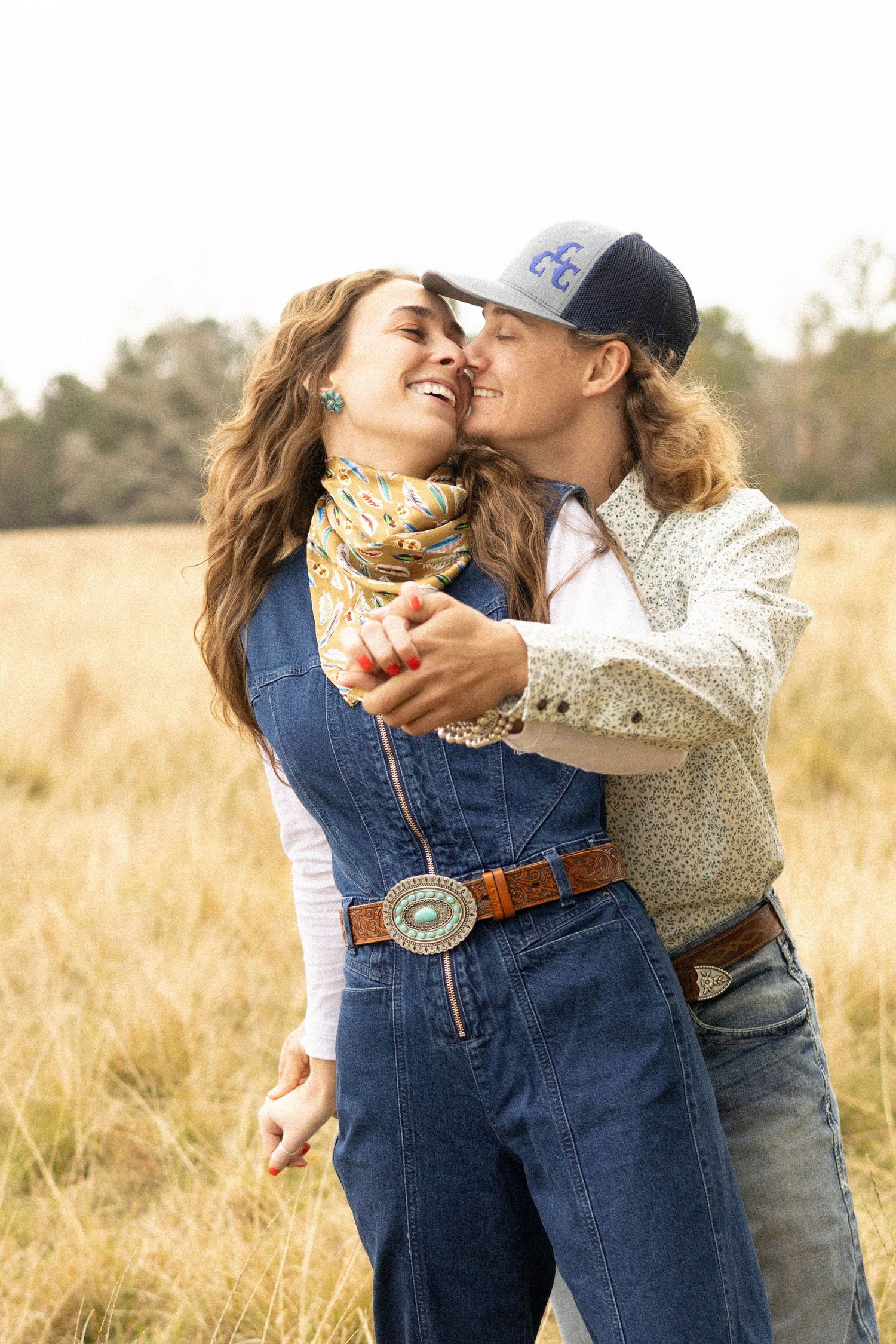 A couple sharing a tender moment while dancing in a sunlit autumn field.