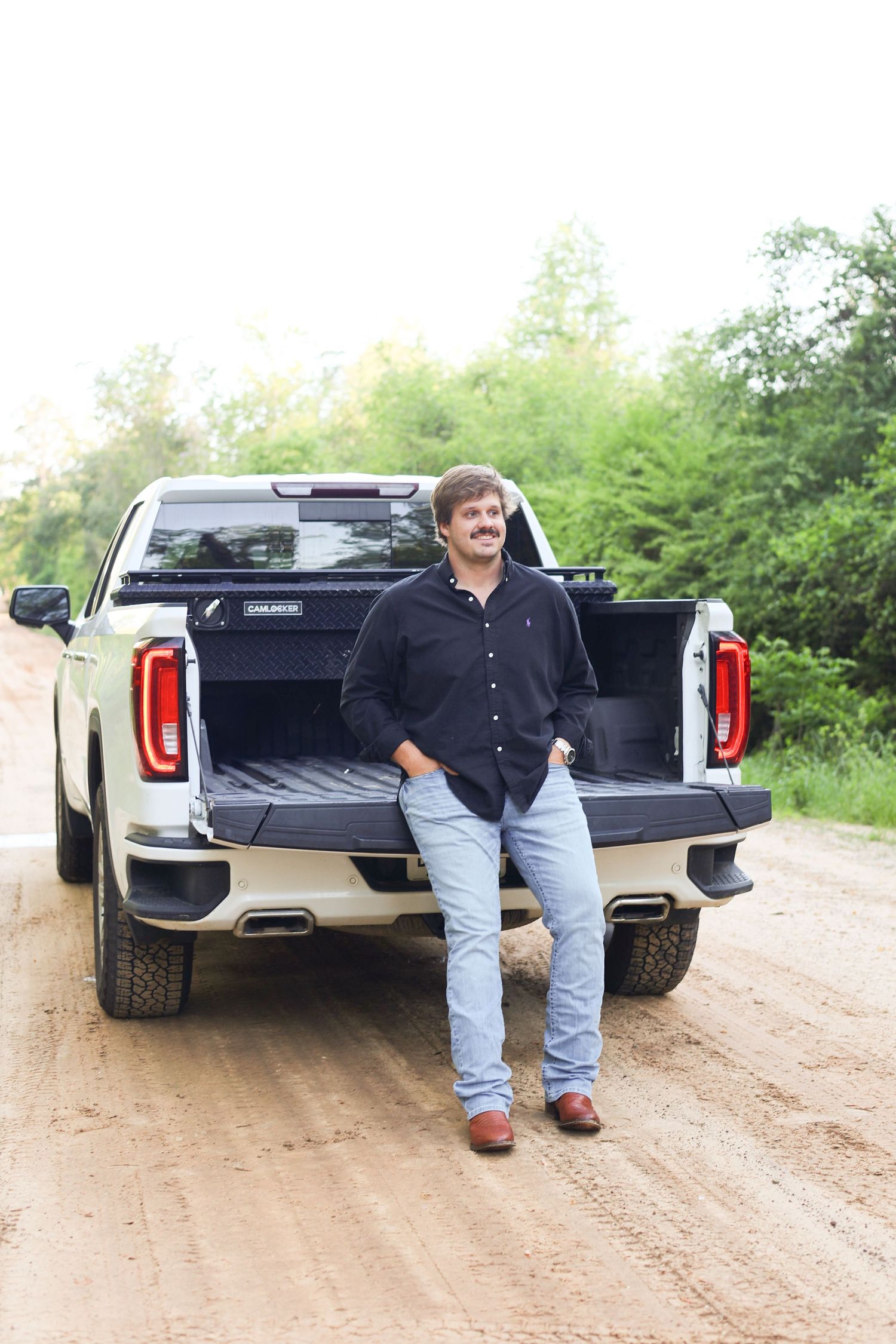 Series of casual poses with pickup truck on dirt road.