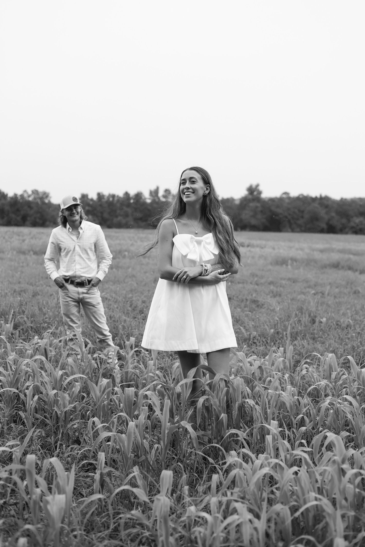 Black and white photo of couple sharing intimate moments in a cornfield.