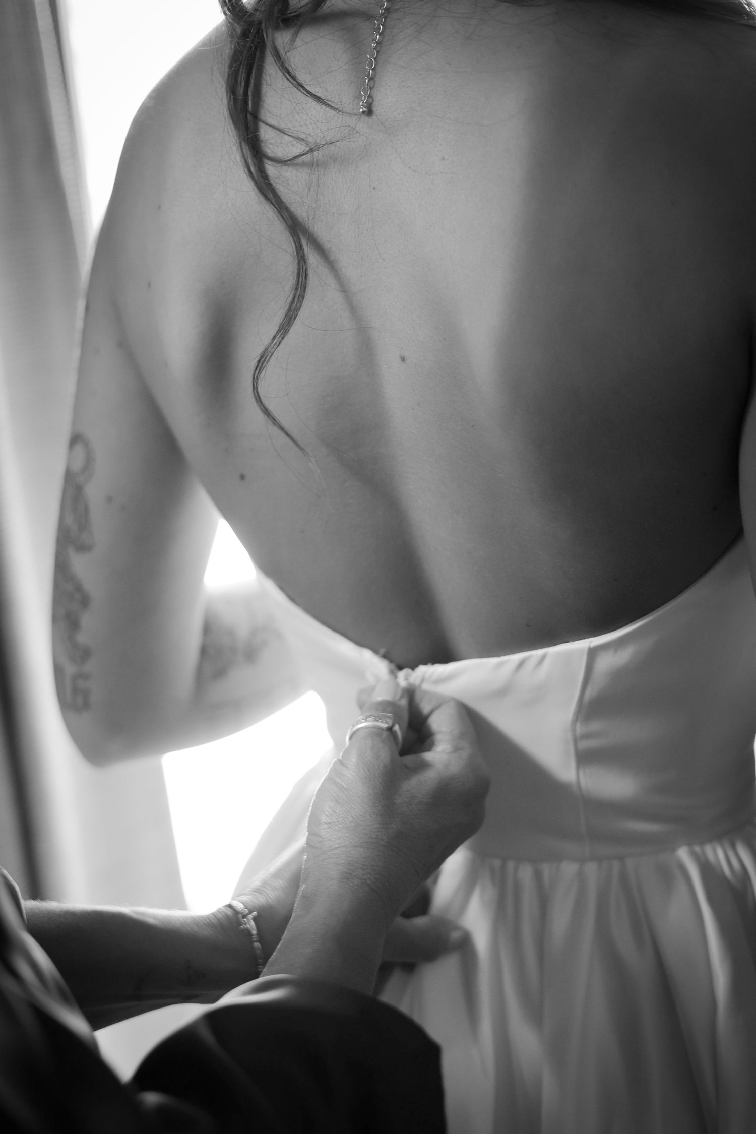 Close-up black and white detail of a strapless wedding dress showing back details.