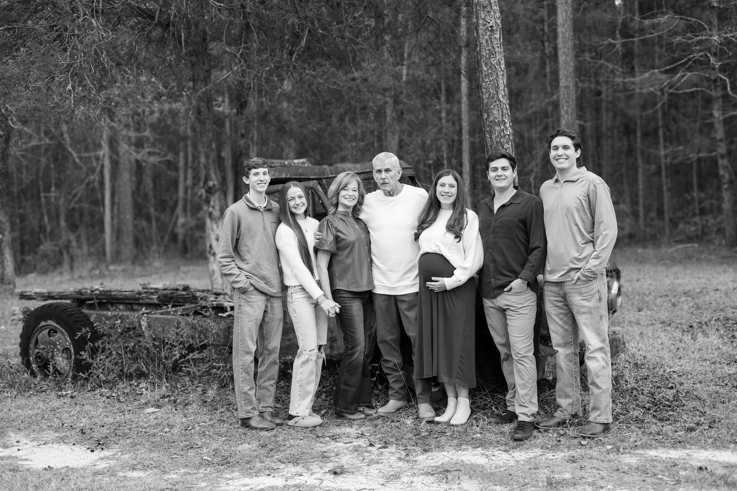 A series of black and white photographs showing people gathered outdoors in a wooded area.
