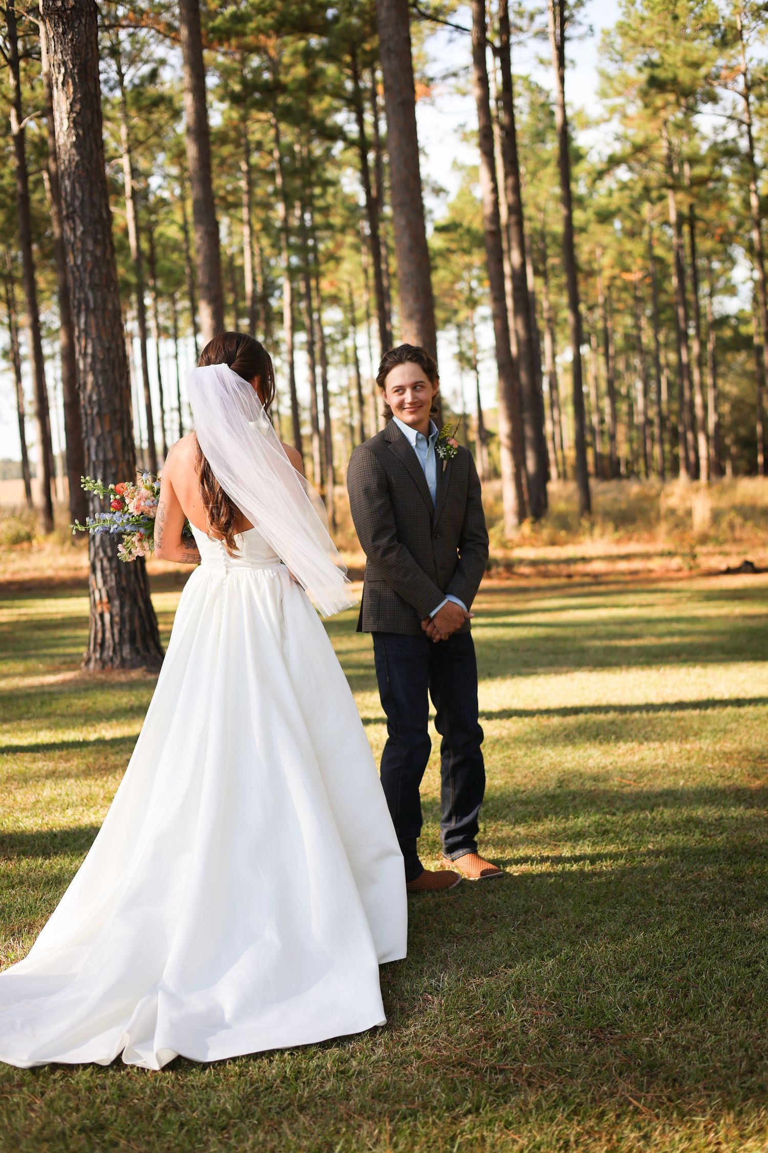 First look moment captured in a pine forest with golden afternoon light.