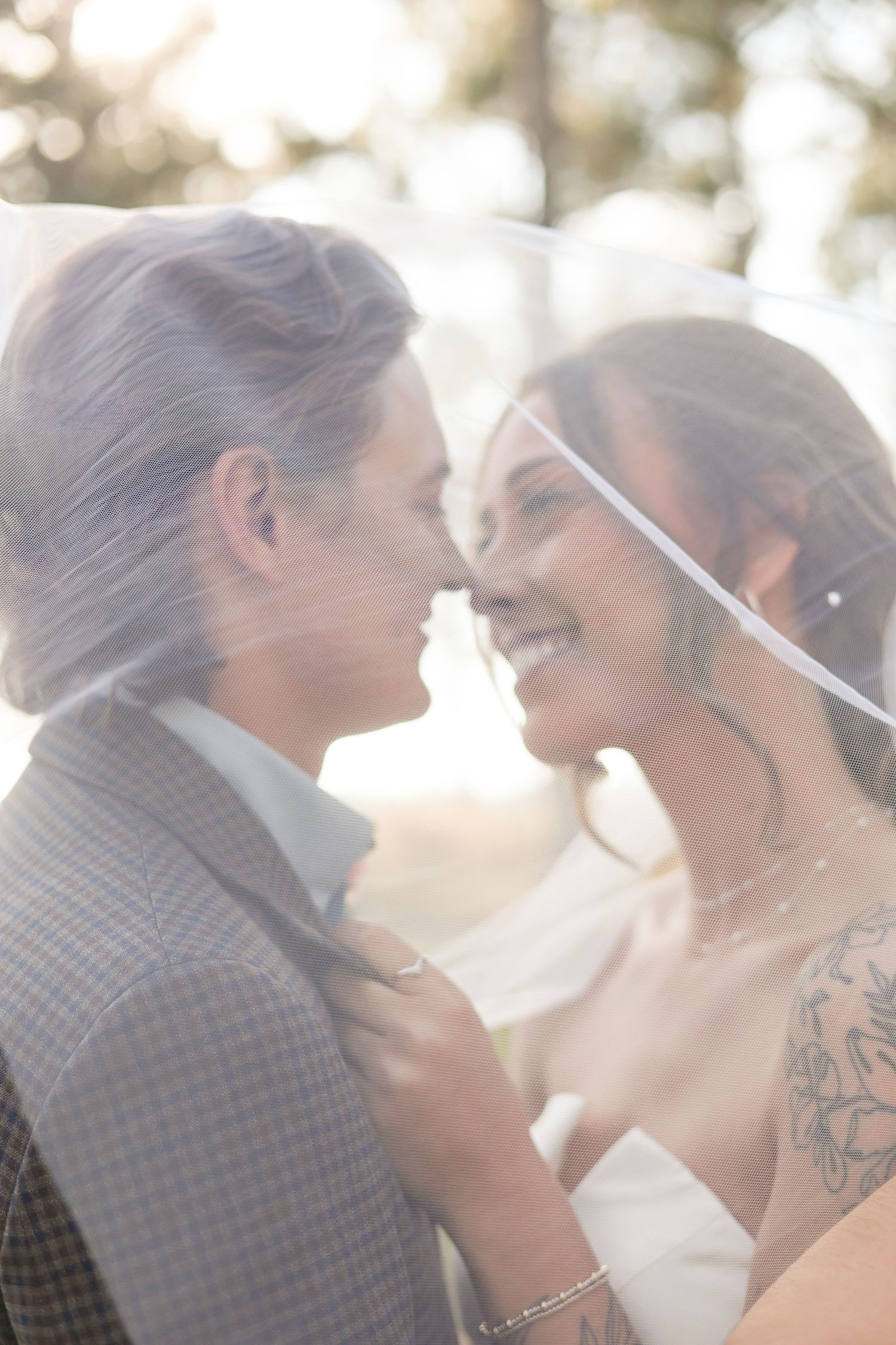 An intimate close-up wedding moment captured in dreamy golden sunlight.
