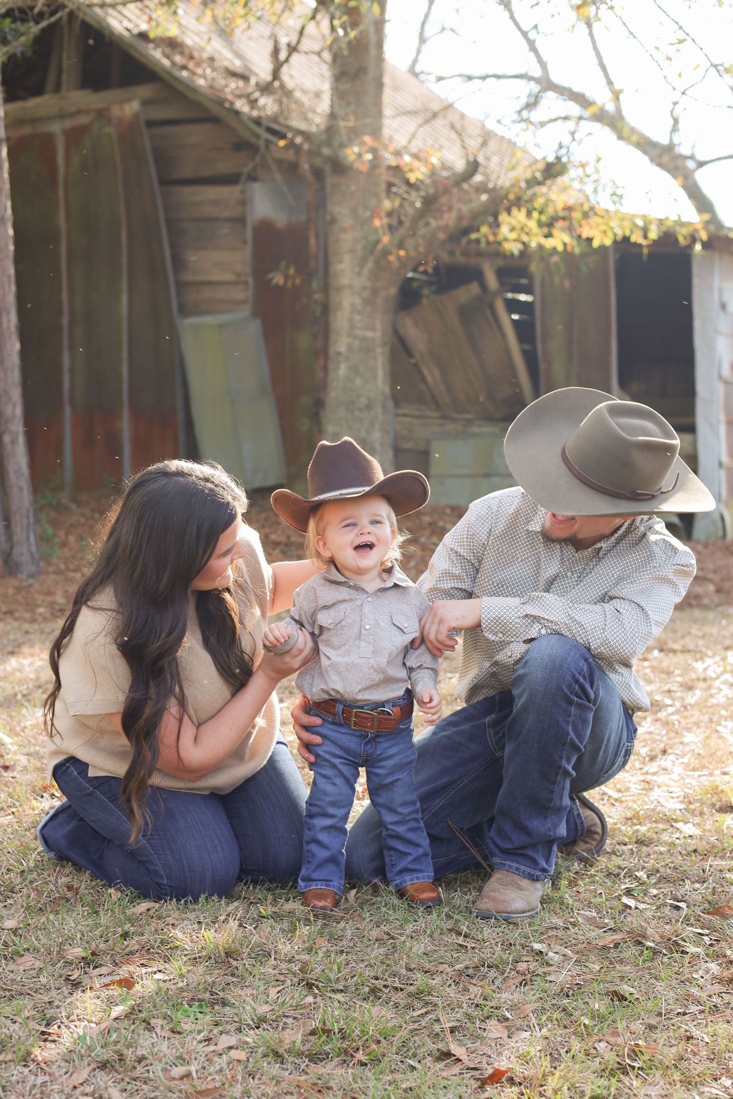 A sequence of four photos showing a family lying on autumn leaves in matching denim outfits near a rustic cabin.