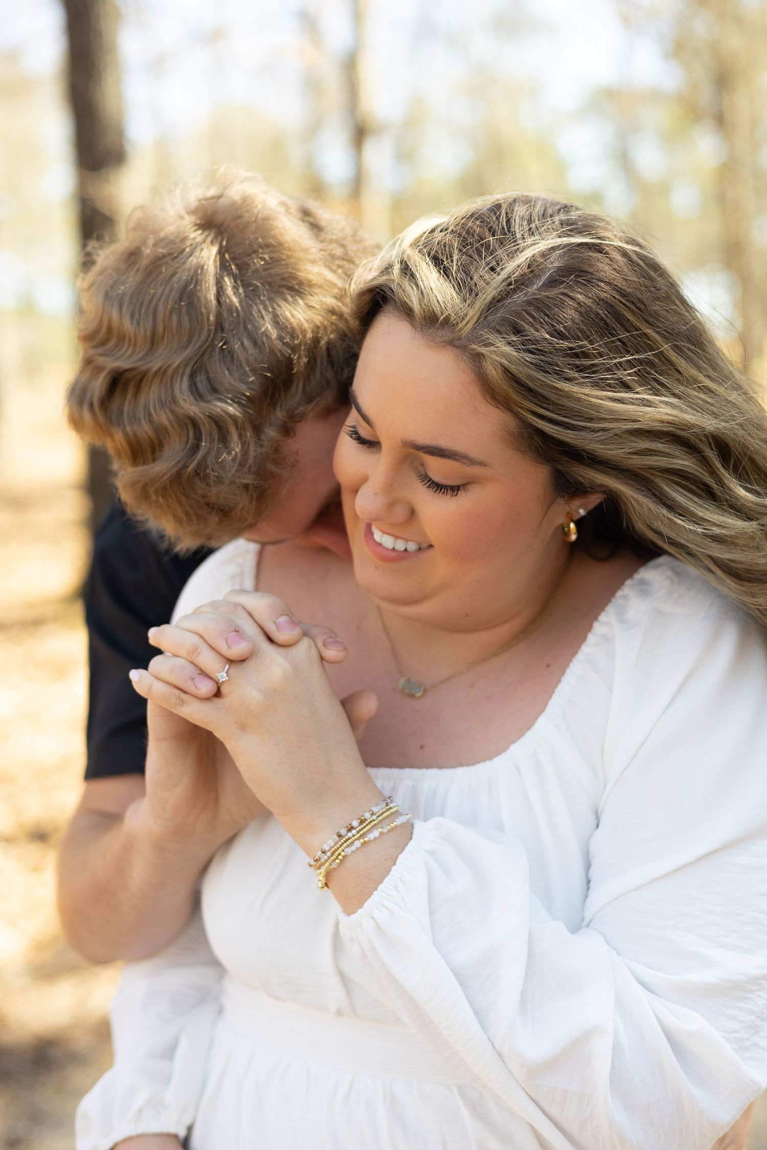 A series of four tender moments captured between a couple in white clothing outdoors with natural lighting.